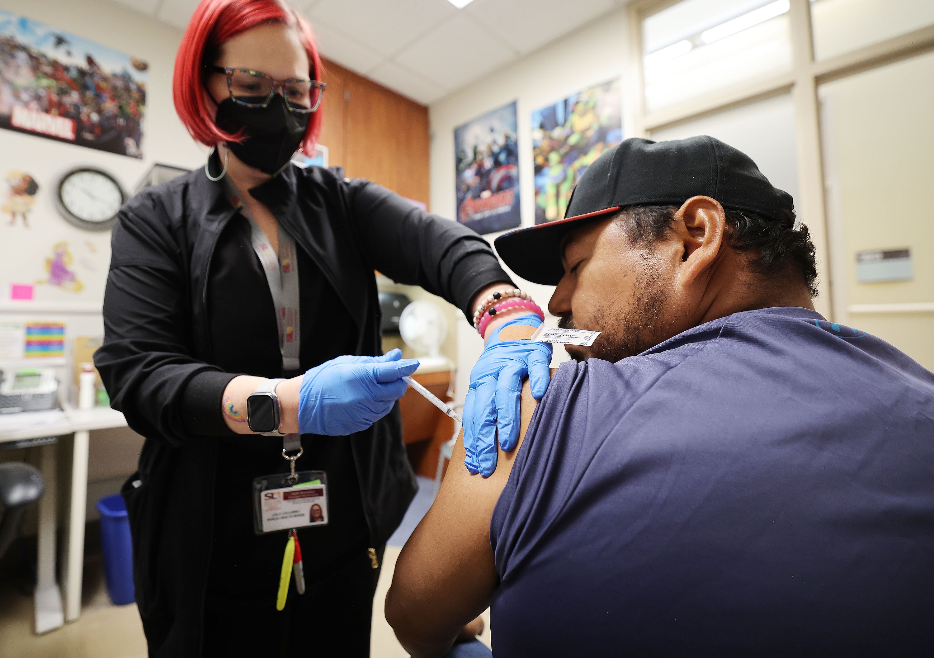 Hugo Varguez receives his COVID-19 vaccine from registered nurse Leila Callaway at Salt Lake County Health Center in Salt Lake City on Oct. 4, 2023. A new study found that alternating arms for vaccine doses may increase immunity.