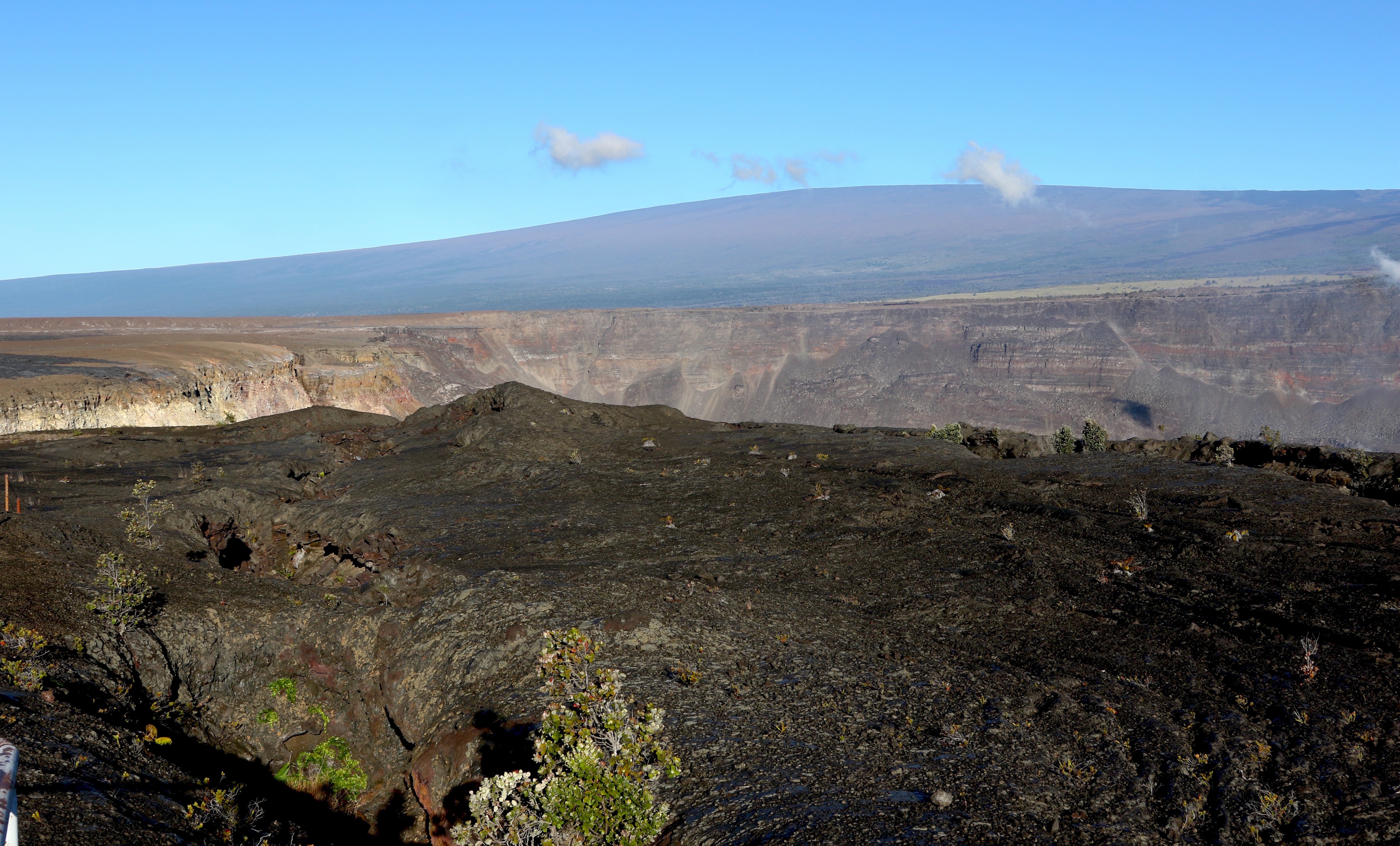 Hawaii's Mauna Loa volcano, background, towers over the summit crater of Kilauea volcano in Hawaii Volcanoes National Park on the Big Island on April 25, 2019. A magnitude 5.7 earthquake struck the world's largest active volcano Friday.
