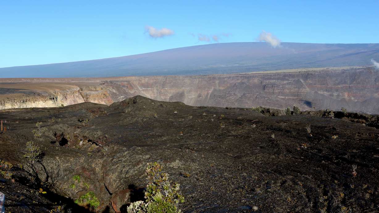 Hawaii's Mauna Loa volcano, background, towers over the summit crater of Kilauea volcano in Hawaii Volcanoes National Park on the Big Island on April 25, 2019. A magnitude 5.7 earthquake struck the world's largest active volcano Friday.