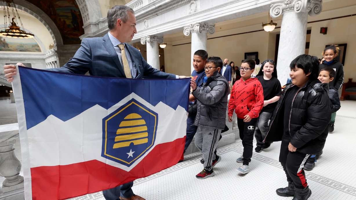 Sen. Daniel McCay, R-Riverton, shows fifth grade students from Academy Park Elementary School the new Utah state flag at the Capitol March 2, 2023. Foes of the flag filed a federal lawsuit Thursday to retain the historic dark blue flag.
