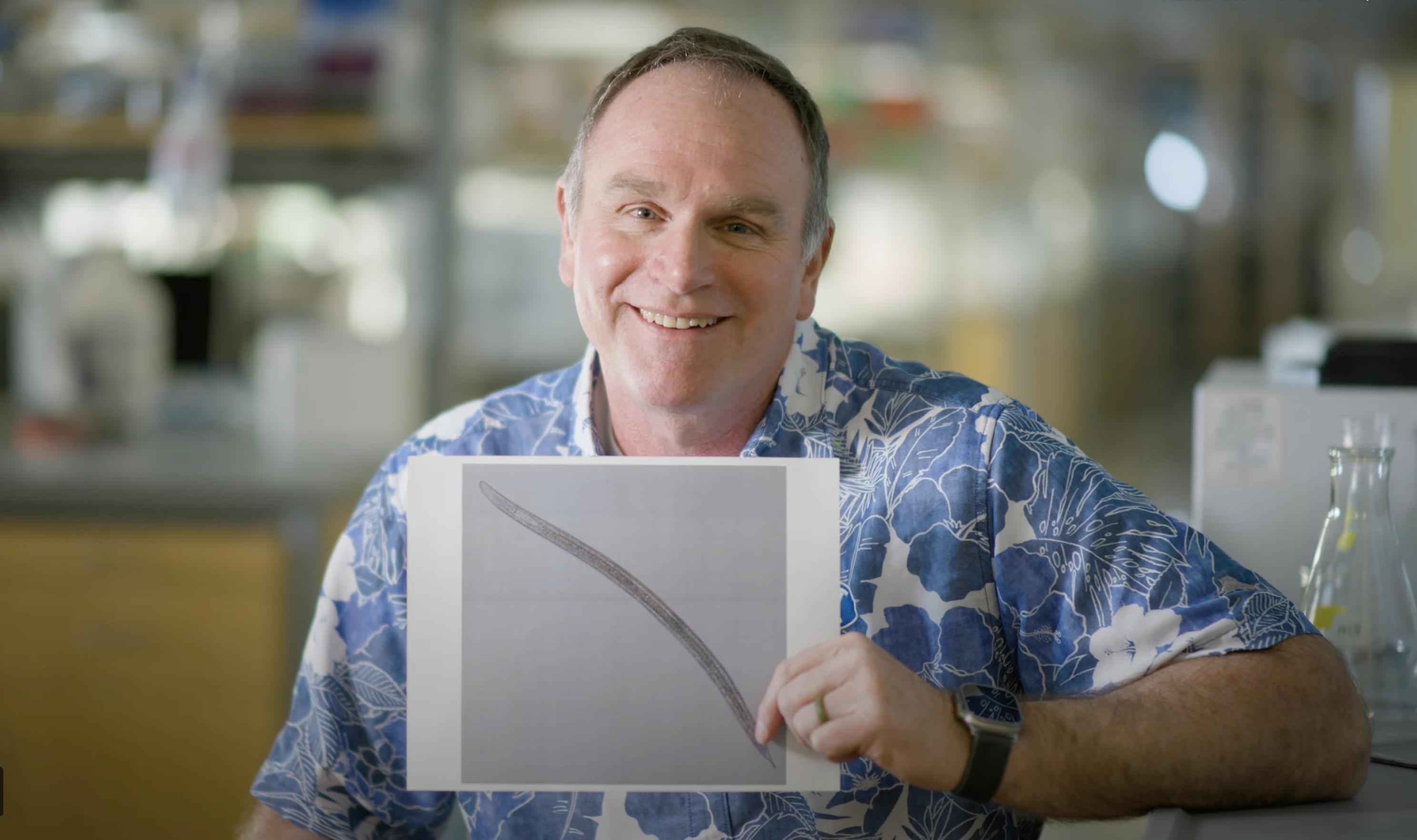 BYU biology professor Byron Adams shows off a picture of Steinernema adamsi, a nematode his former student discovered and named in honor of him.