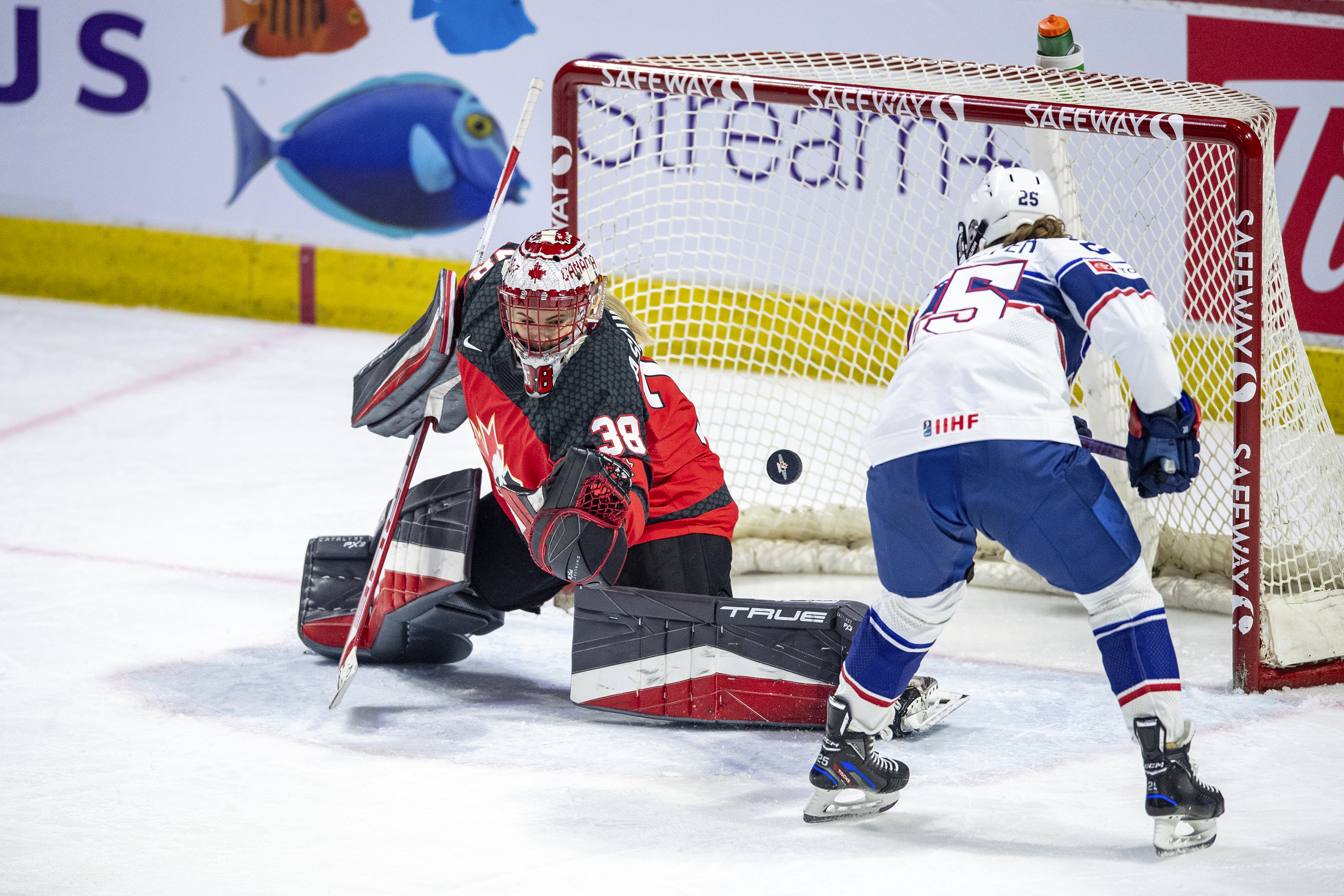 Canada goaltender Emerance Maschmeyer (38) stops a shot as United States' Alex Carpenter (25) looks for a rebound during the second period of a Rivalry Series hockey game Friday, Feb. 9, 2024, in Regina, Saskatchewan. 