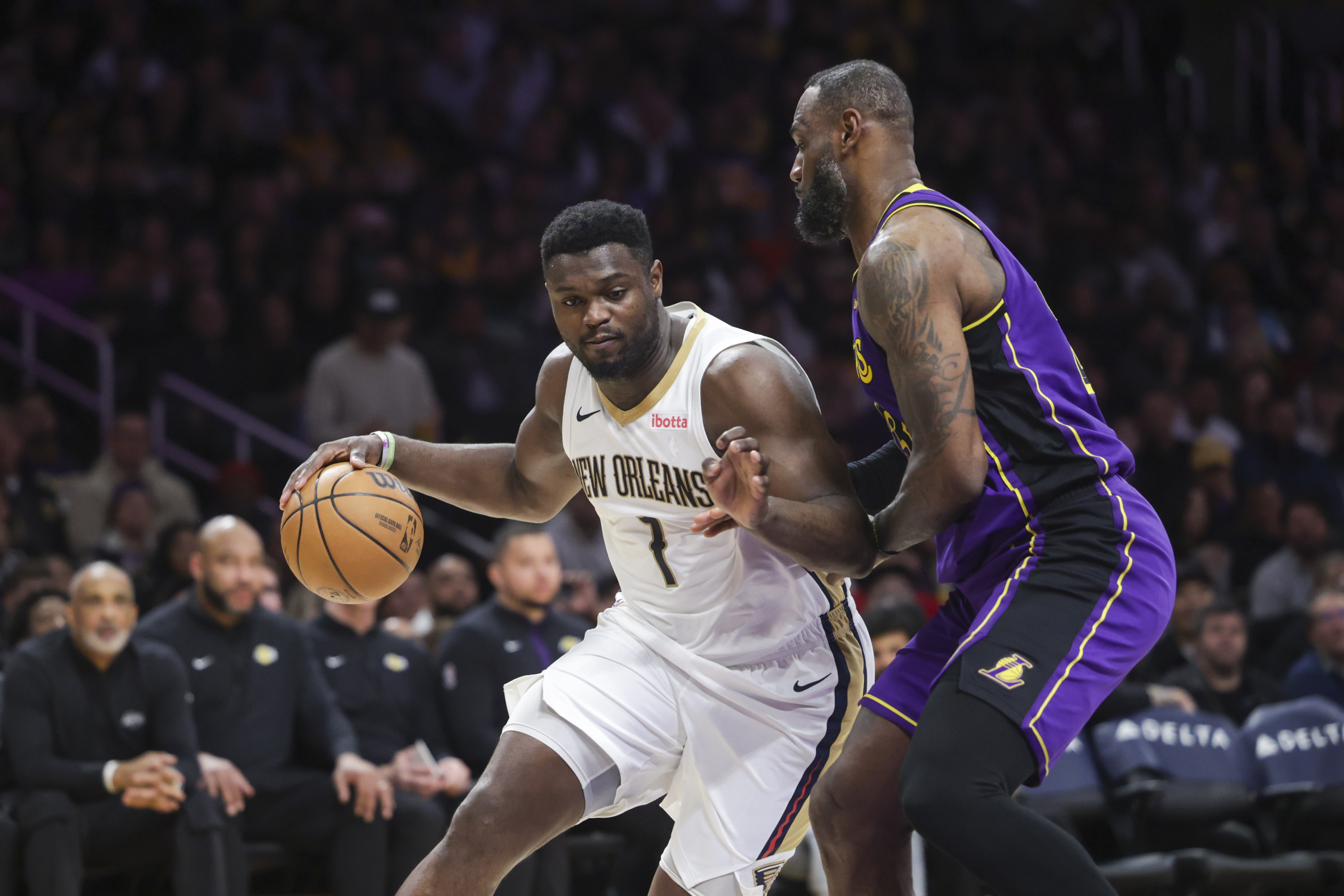 New Orleans Pelicans forward Zion Williamson (1) dribbles the ball as Los Angeles Lakers forward LeBron James defends during the first half of an NBA basketball game Friday, Feb. 9, 2024, in Los Angeles.