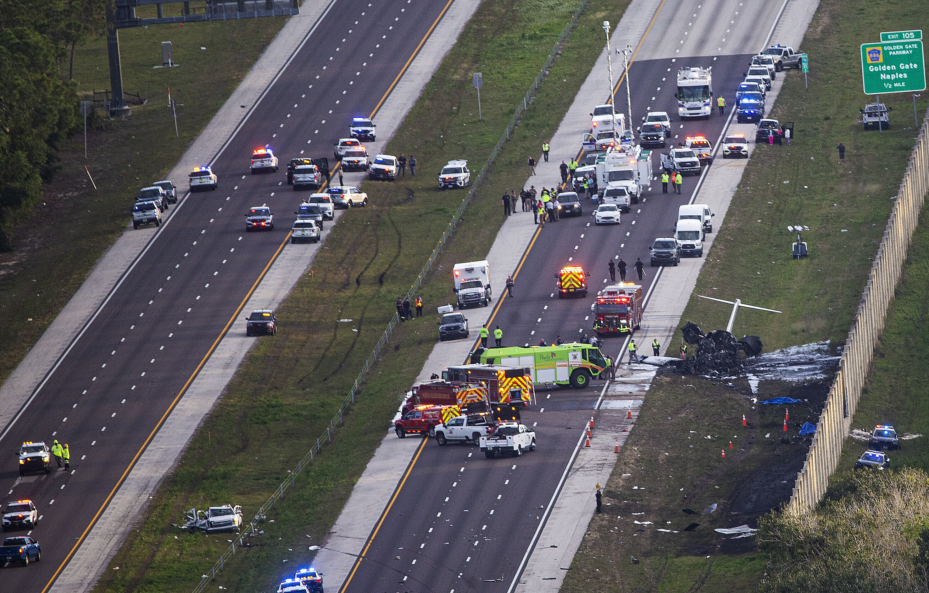 Emergency officials work the scene of a small plane crash on Interstate 75 in Naples, Fla., Friday. Two people were confirmed dead.