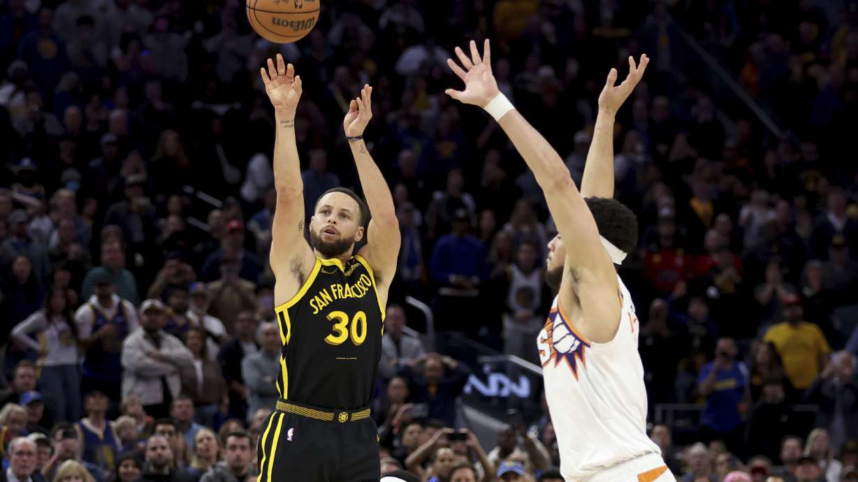Golden State Warriors guard Stephen Curry (30) shoots a go-ahead basket against Phoenix Suns guard Devin Booker, right, during the second half of an NBA basketball game in San Francisco, Saturday, Feb. 10, 2024.