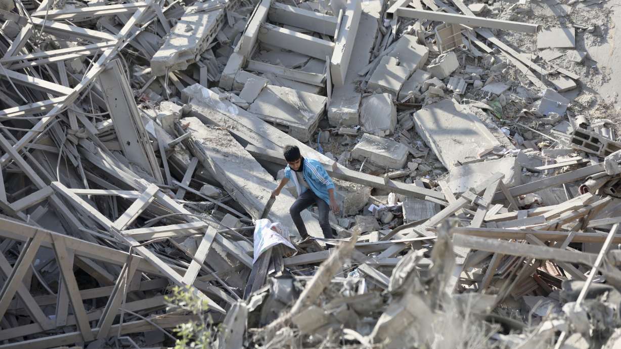 Palestinians walk through the destruction left by the Israeli air and ground offensive on the Gaza Strip in Gaza City, Saturday.