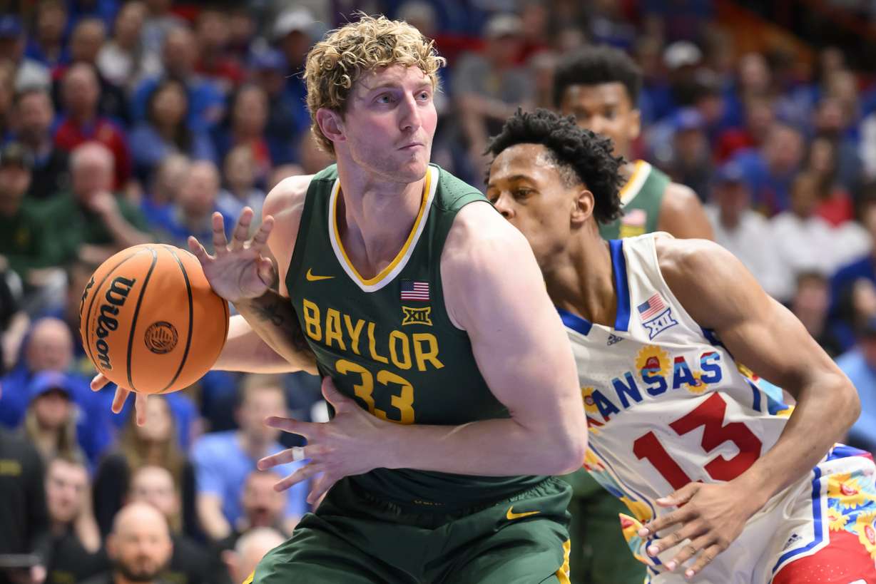 Kansas guard Elmarko Jackson (13) tries to knock the ball away from Baylor forward Caleb Lohner (33) during the second half of an NCAA college basketball game in Lawrence, Kan., Saturday, Feb. 10, 2024.