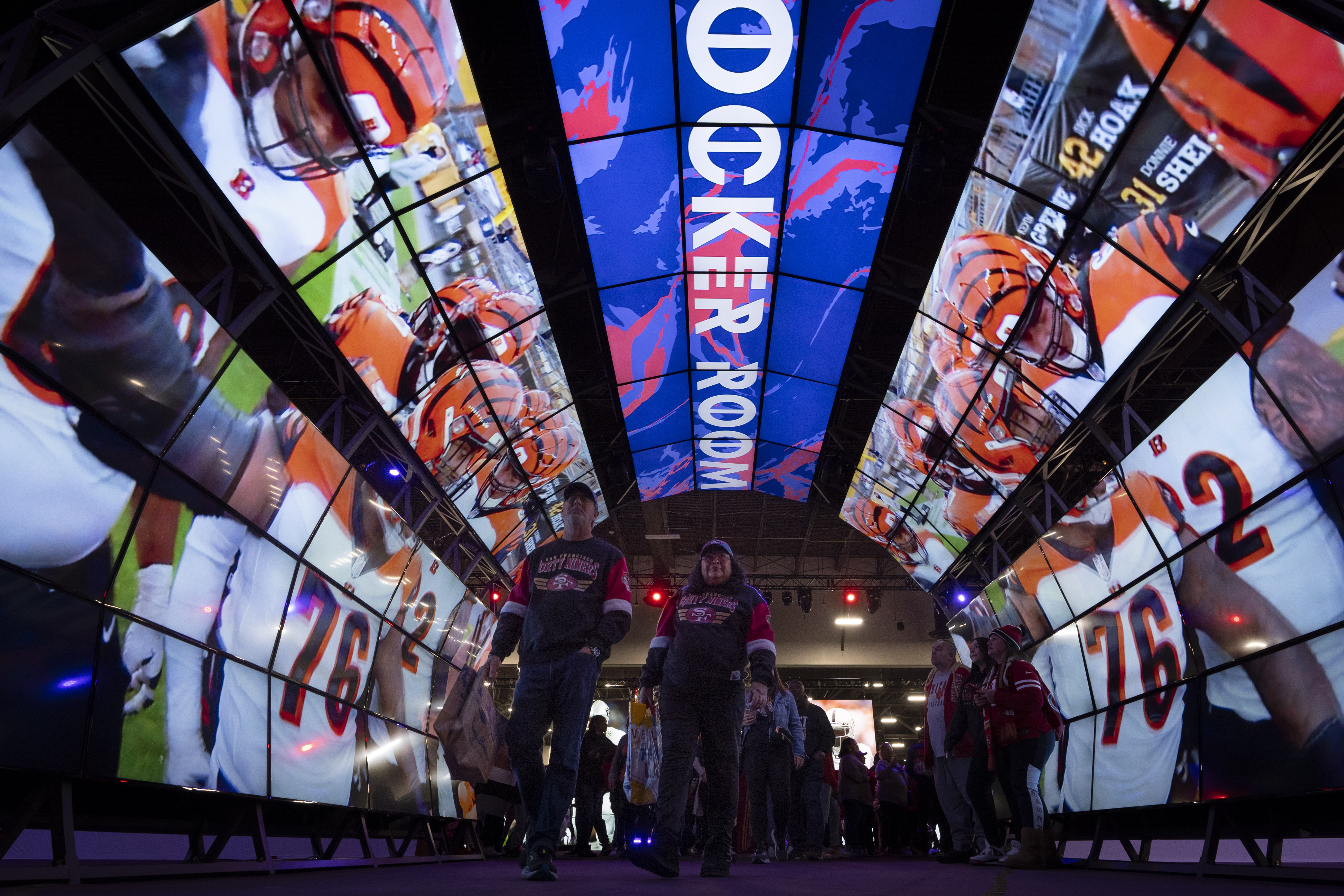 Fans walk through a tunnel of digital screens during NFL Experience ahead of Super Bowl 58, Saturday, Feb. 10, 2024, in Las Vegas. The Kansas City Chiefs will play the NFL football game against the San Francisco 49ers Sunday. 