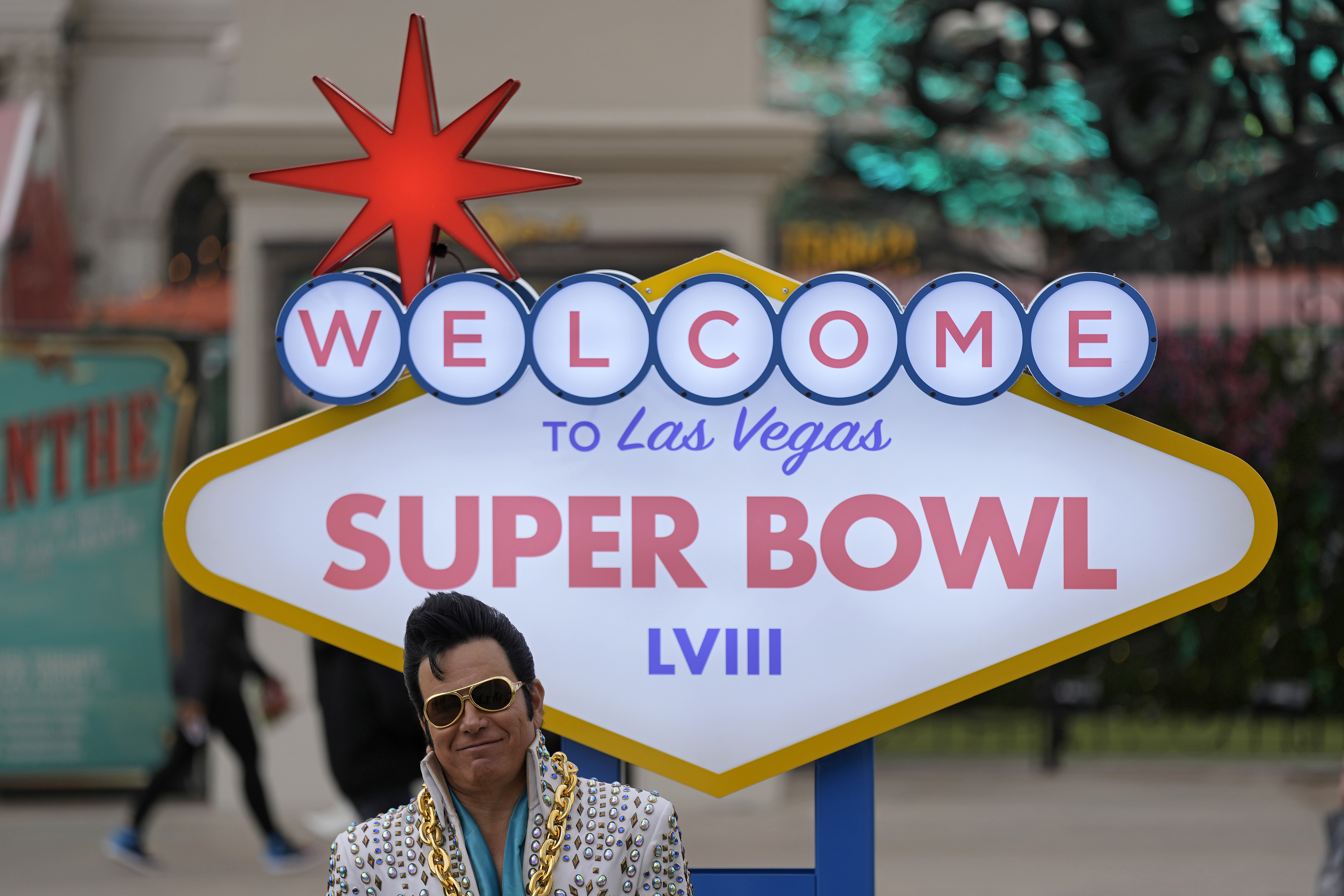 An Elvis impersonator waits to have his photo taken with visitors in front of a Super Bowl 58 sign at Caesars Palace Friday, Feb. 9, 2024 in Las Vegas. The Kansas City Chiefs will play the NFL football game against the San Francisco 49ers Sunday. 