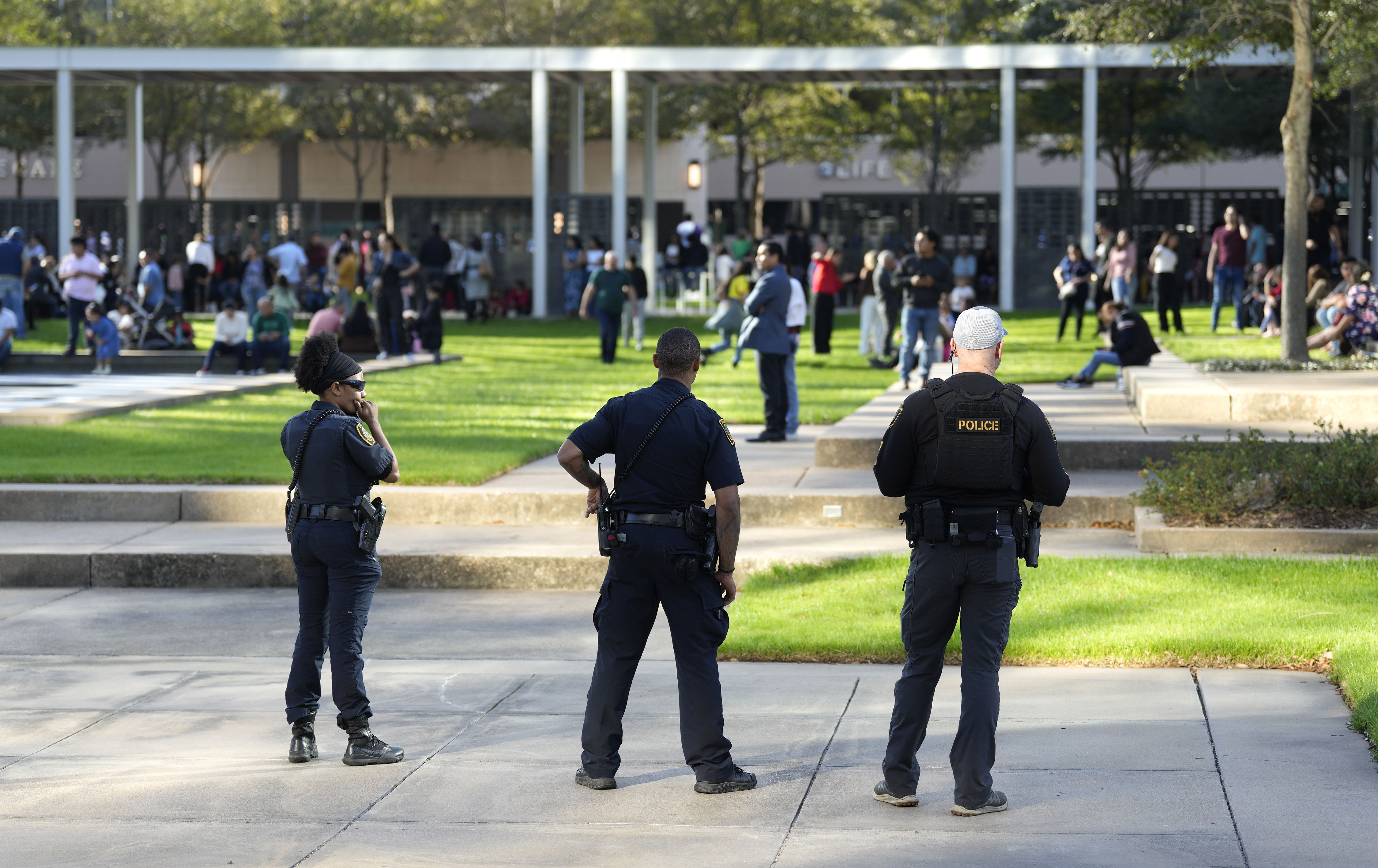 Houston police officers watch over displaced churchgoers outside Lakewood Church, Sunday in Houston, after a reported shooting during a Spanish church service. 