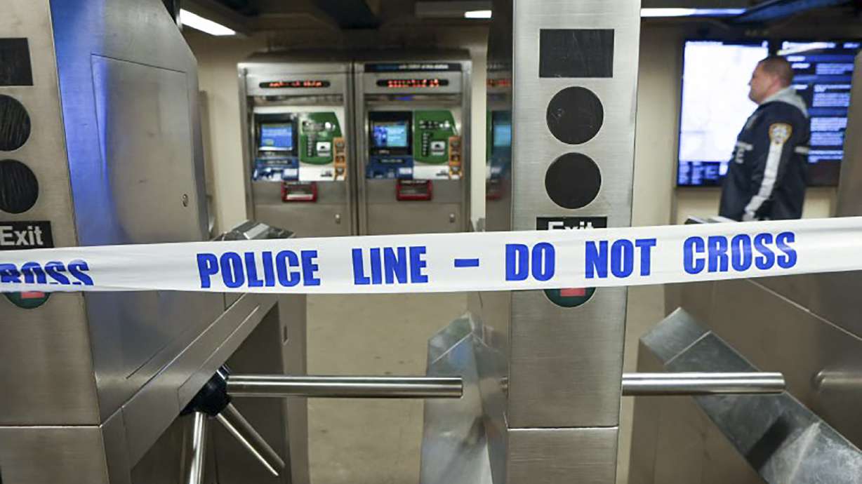 New York Police walk through the Mount Eden subway station while investigating a shooting, Monday in the Bronx borough of New York. Several people were shot Monday at the New York City subway station, police said.