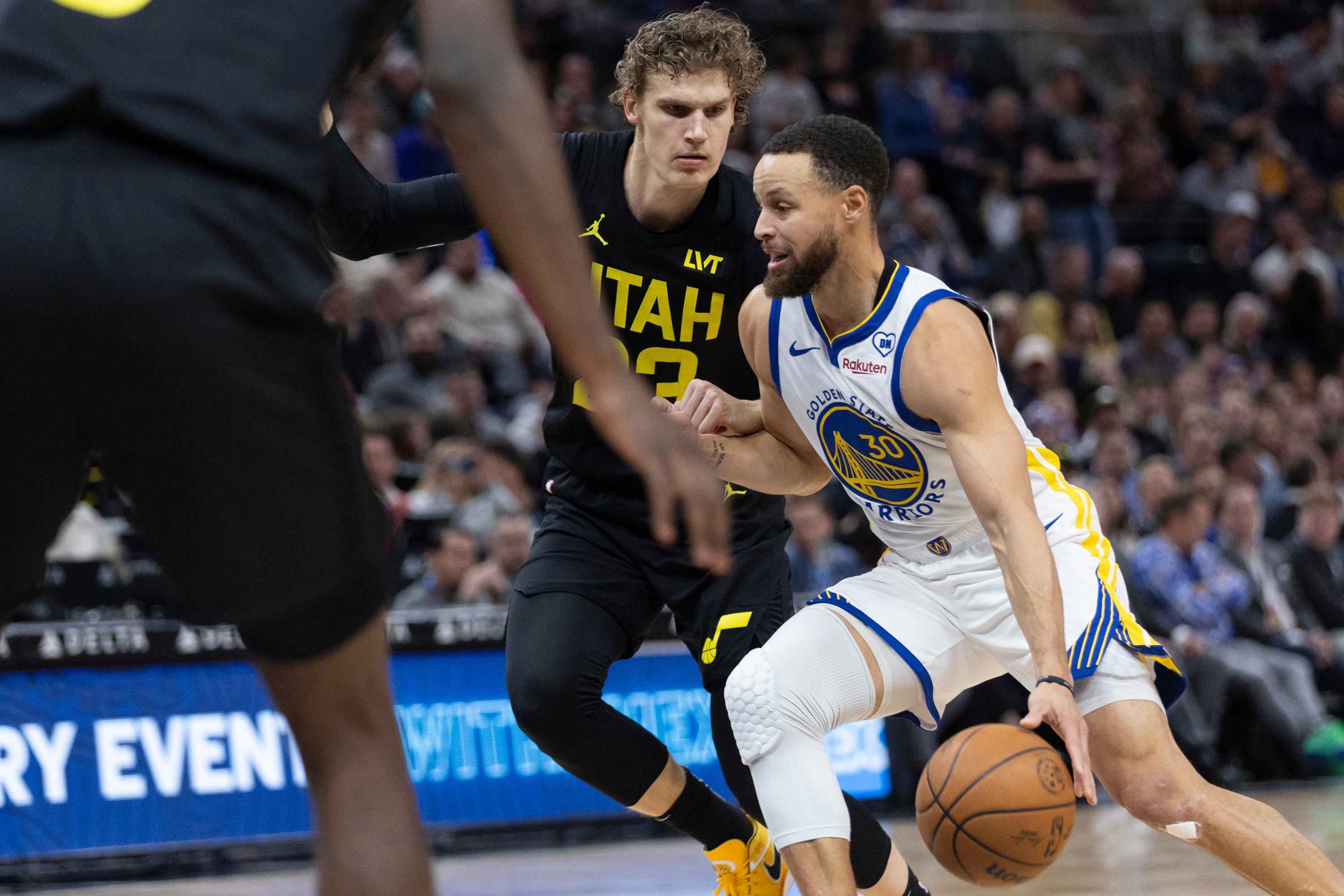 Utah Jazz forward Lauri Markkanen (23) defends against  Golden State Warriors guard Stephen Curry (30) during the first half of a game at the Delta Center in Salt Lake City on Monday, Feb. 12, 2024.