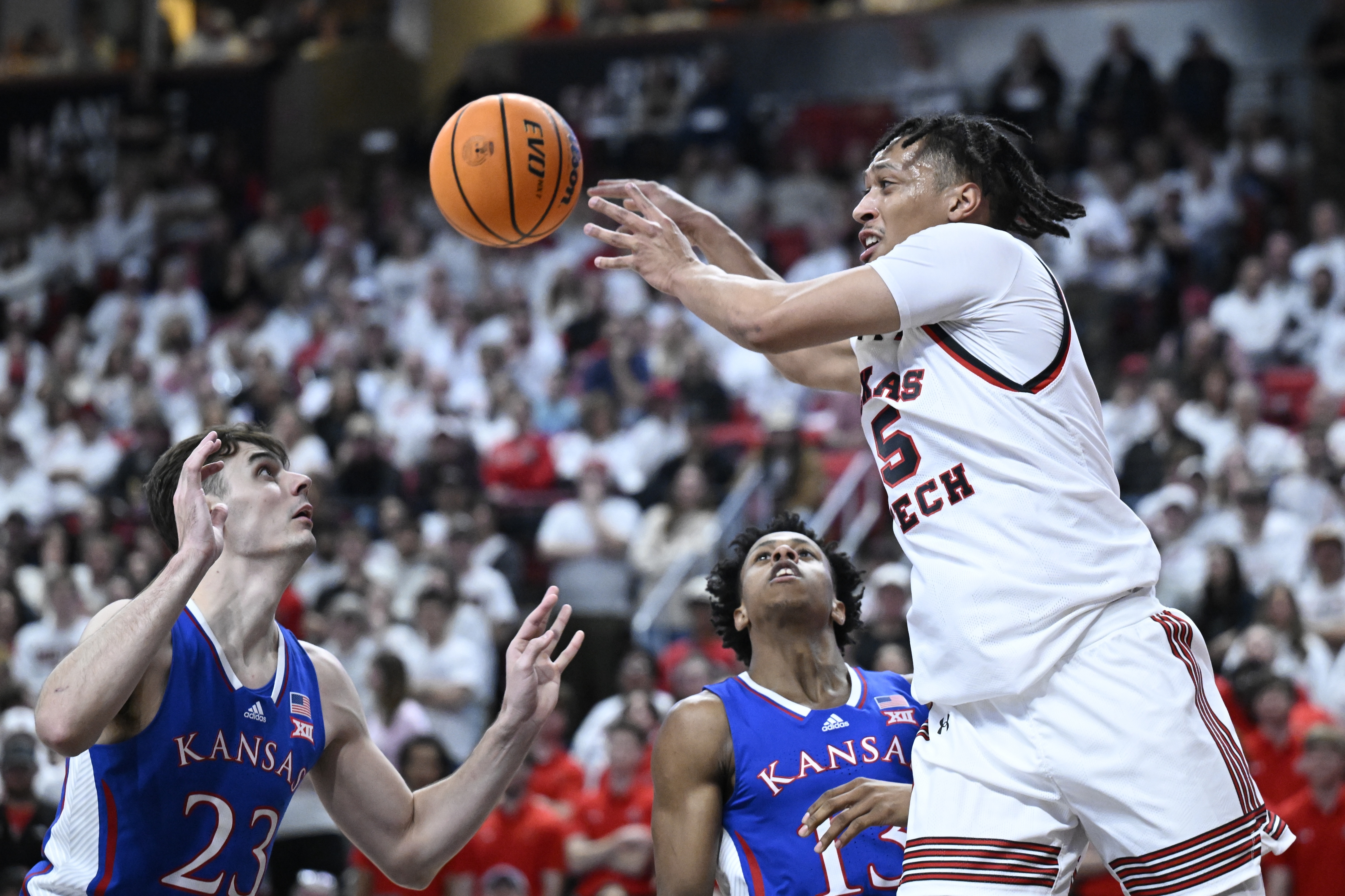 Texas Tech guard Darrion Williams (5) passes the ball against Kansas forward Parker Braun (23) and guard Elmarko Jackson, center, during the first half of an NCAA college basketball game, Monday, Feb. 12, 2024, in Lubbock, Texas. 
