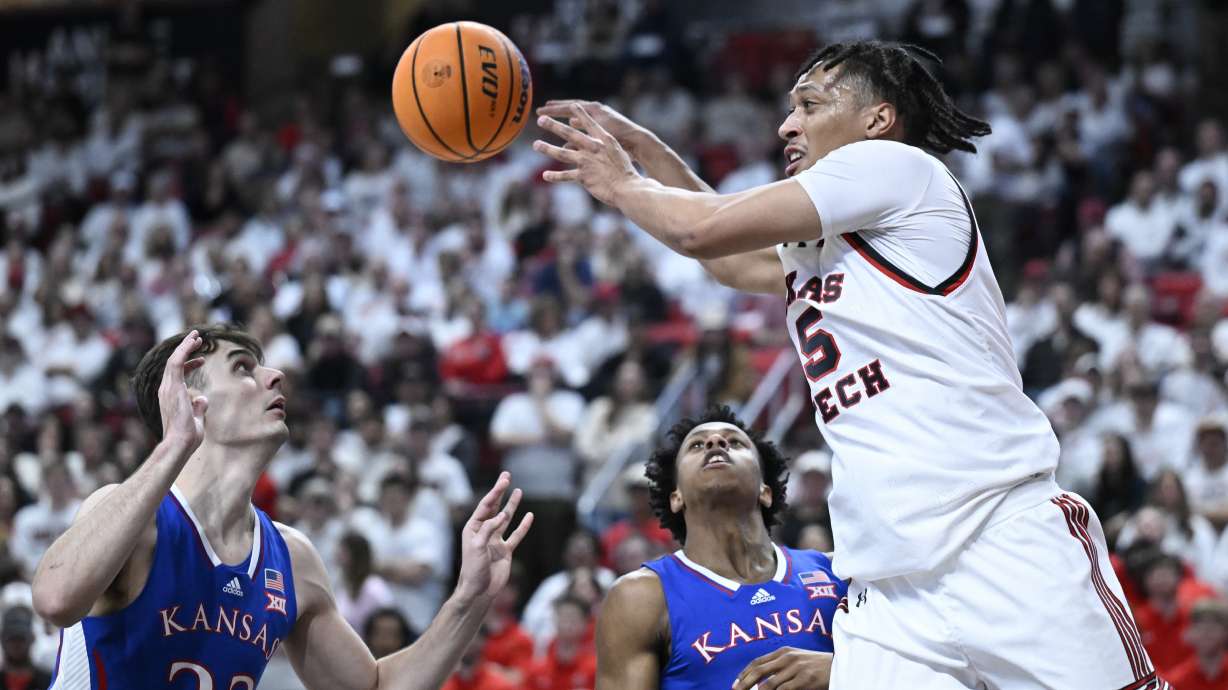 Texas Tech guard Darrion Williams (5) passes the ball against Kansas forward Parker Braun (23) and guard Elmarko Jackson, center, during the first half of an NCAA college basketball game, Monday, Feb. 12, 2024, in Lubbock, Texas.