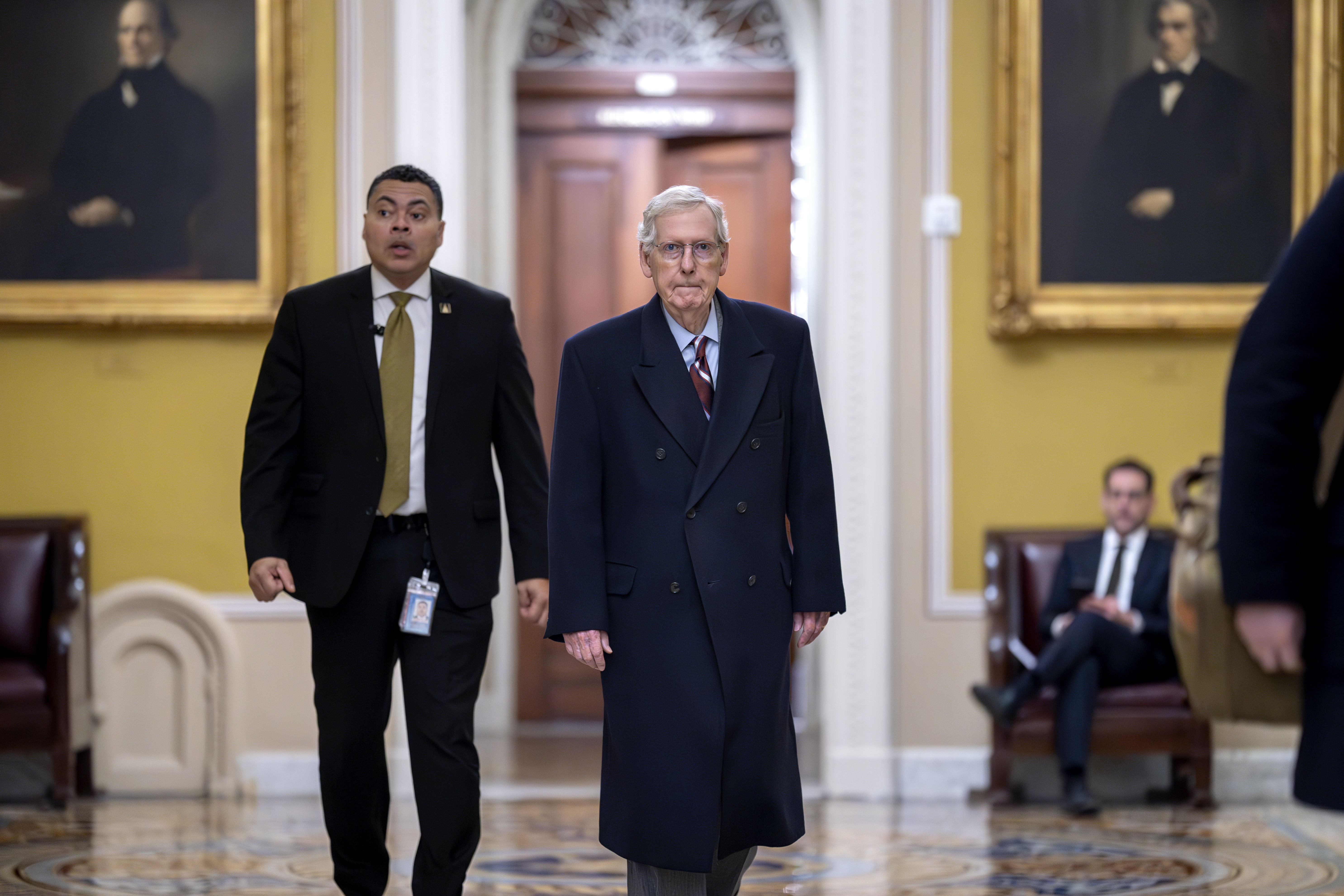 Senate Minority Leader Mitch McConnell, R-Ky., right, arrives as the Senate moves closer to a final vote on an emergency spending package in Washington, Monday. The Senate later passed a $95.3 billion aid package for Ukraine, Israel and Taiwan after almost a week of debate.
