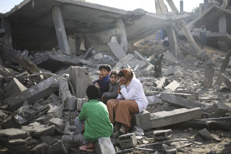 Palestinians sit by the destruction from the Israeli bombardment of the Gaza Strip in Rafah on Monday. Officials say Israel and Hamas are making progress toward a deal to bring about a cease-fire and free hostages.