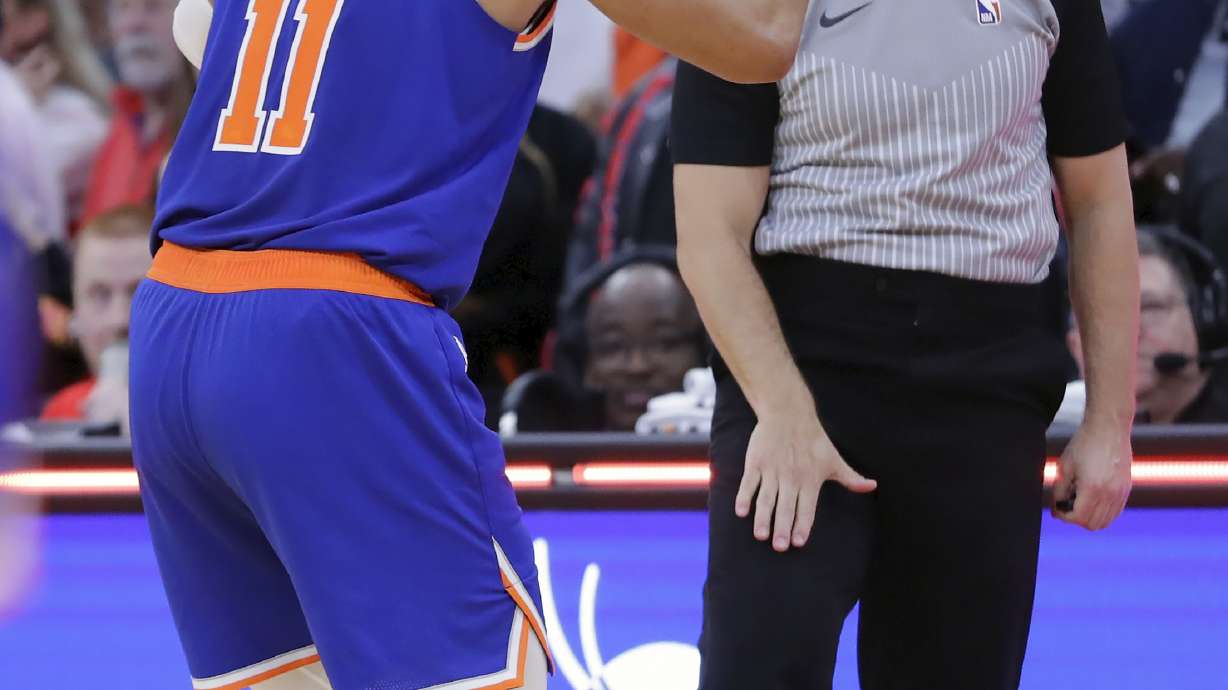 With the game tied and under one second left on the clock, New York Knicks guard Jalen Brunson (11) reacts as he is called for a foul by referee Jacyn Goble, right, when Houston Rockets guard Aaron Holiday was attempting a 3-point shot, setting up the winning free throws for Houston, during the second half of an NBA basketball game Monday, Feb. 12, 2024, in Houston.