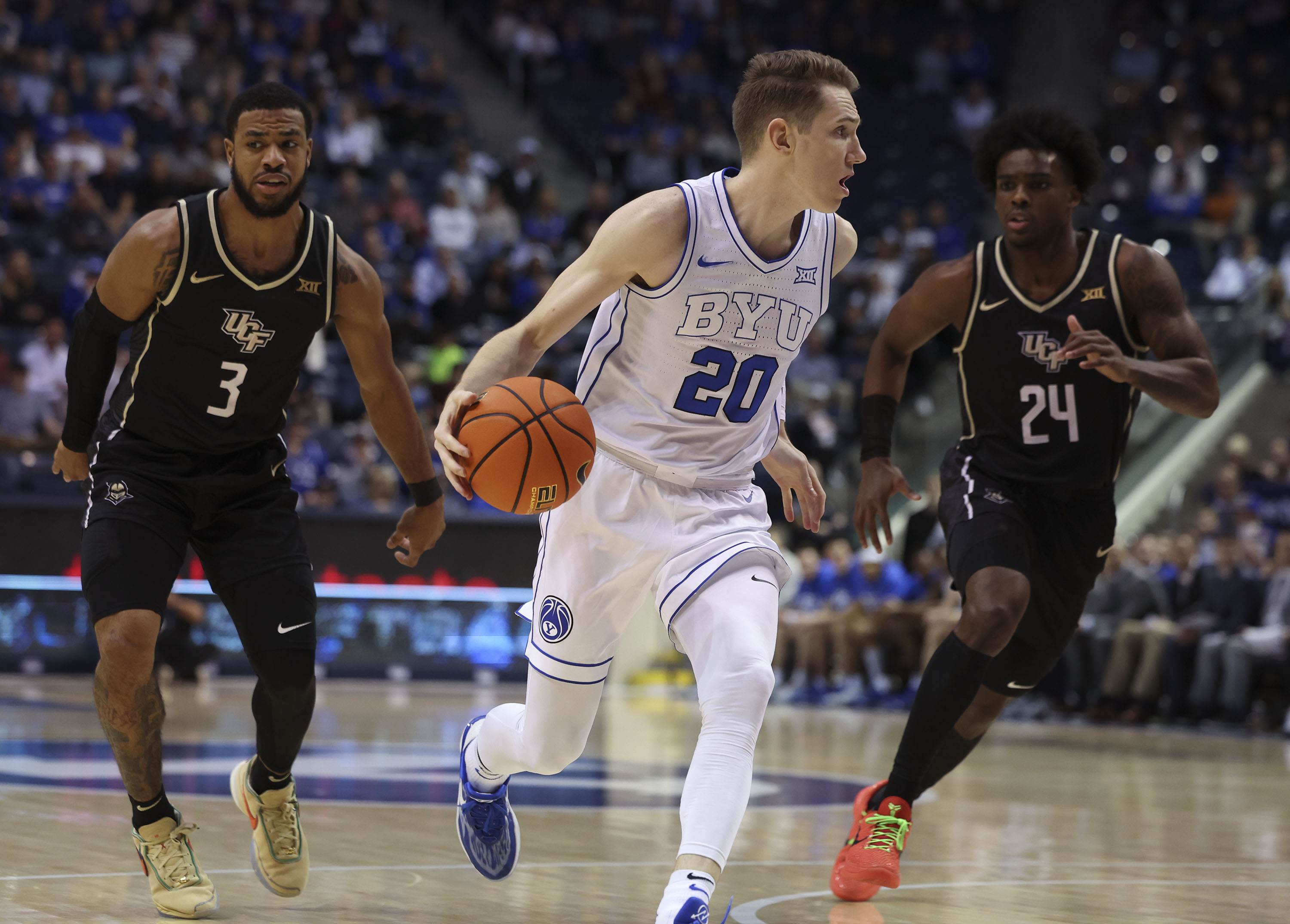 Brigham Young guard Spencer Johnson (20) drives downcourt past UCF guard Darius Johnson (3) and UCF guard Jaylin Sellers (24) at the Marriott Center in Provo on Tuesday, Feb. 13, 2024.