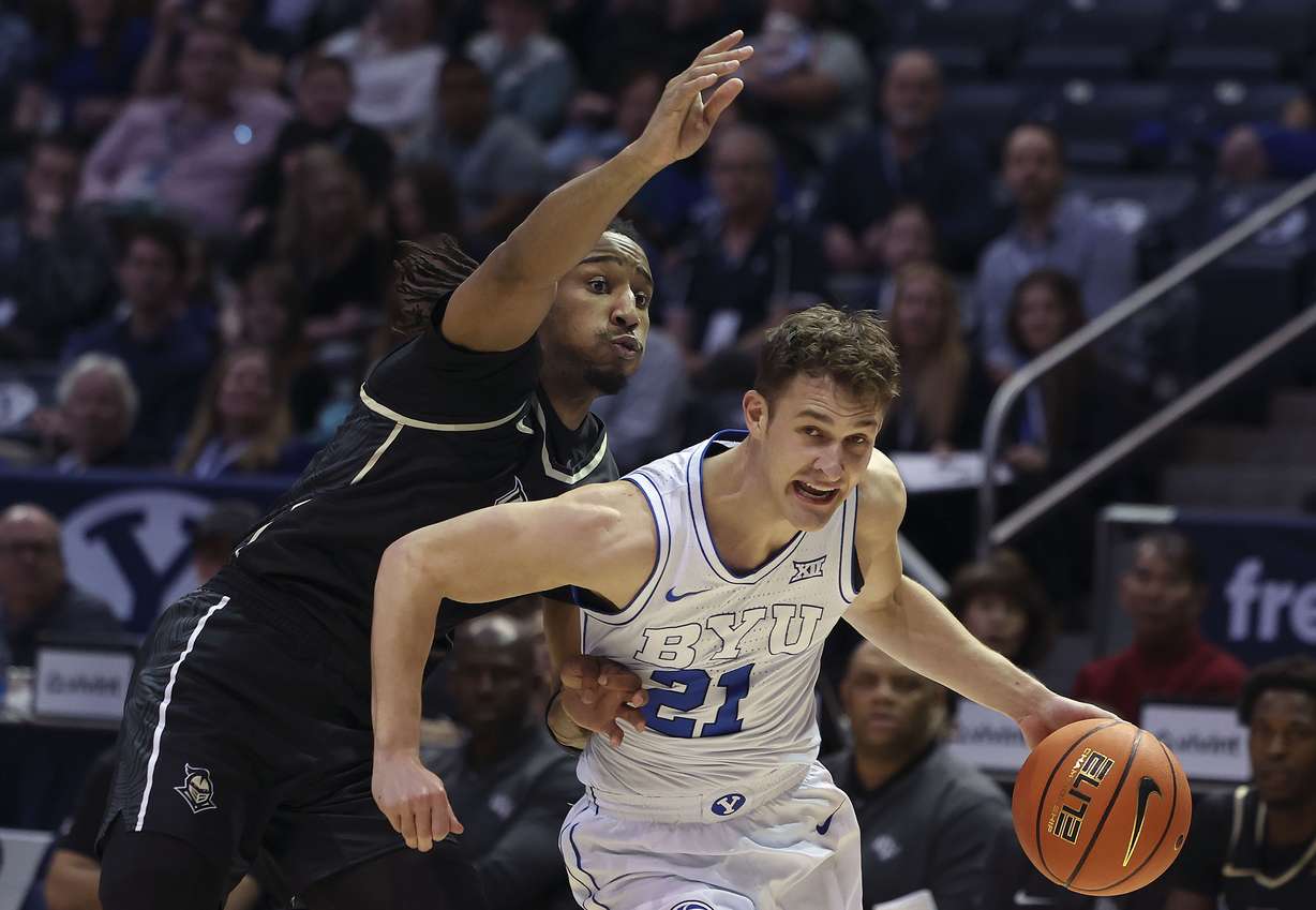 Brigham Young guard Trevin Knell (21) drives past UCF Knights guard Shemarri Allen (2) at the Marriott Center in Provo on Tuesday, Feb. 13, 2024.