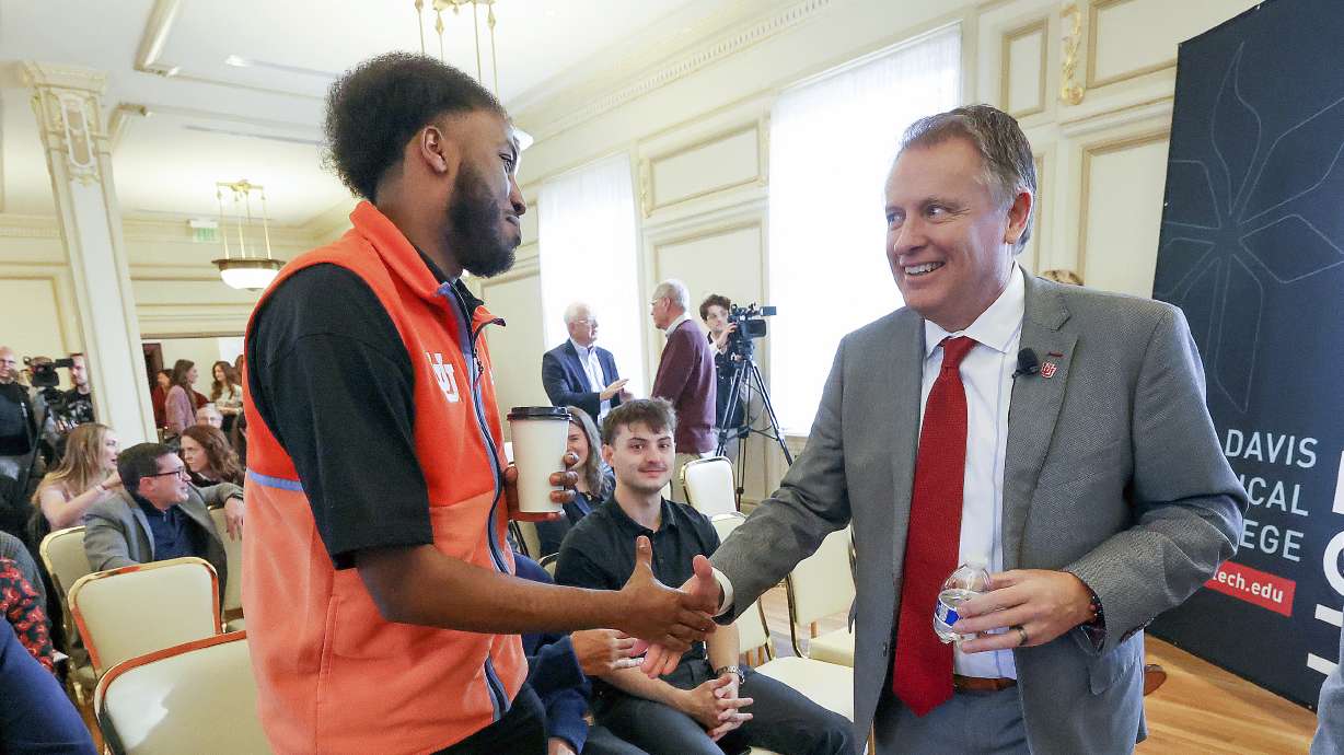 Abukar Hasan shakes hands with University of Utah President Taylor Randall before a panel discussion at a Newsmaker Breakfast at the Thomas S. Monson Center in Salt Lake City on Wednesday.