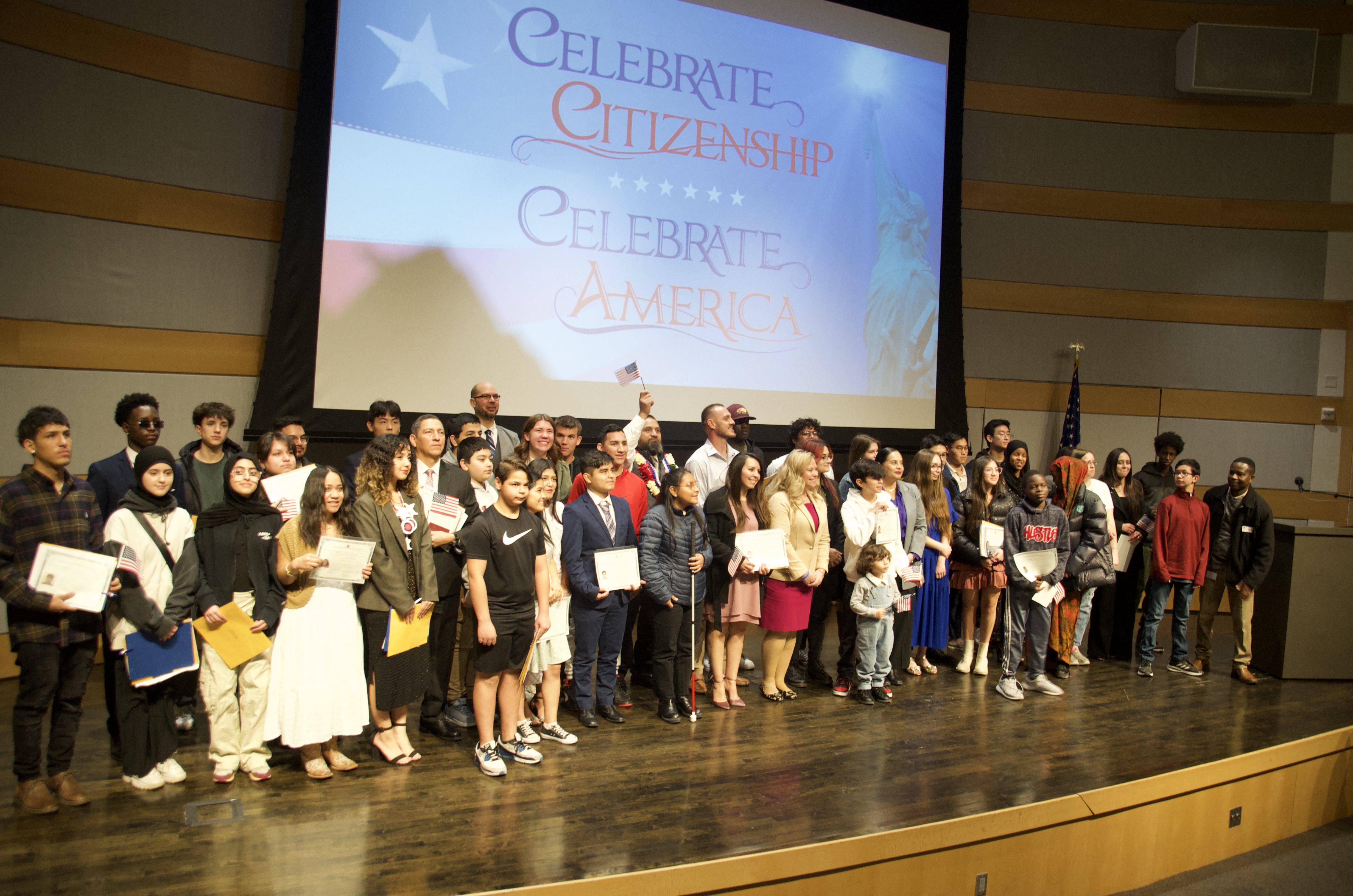 Newly minted U.S. citizens pose with their naturalization certificates at the end of a ceremony Wednesday at the Salt Lake City Library.