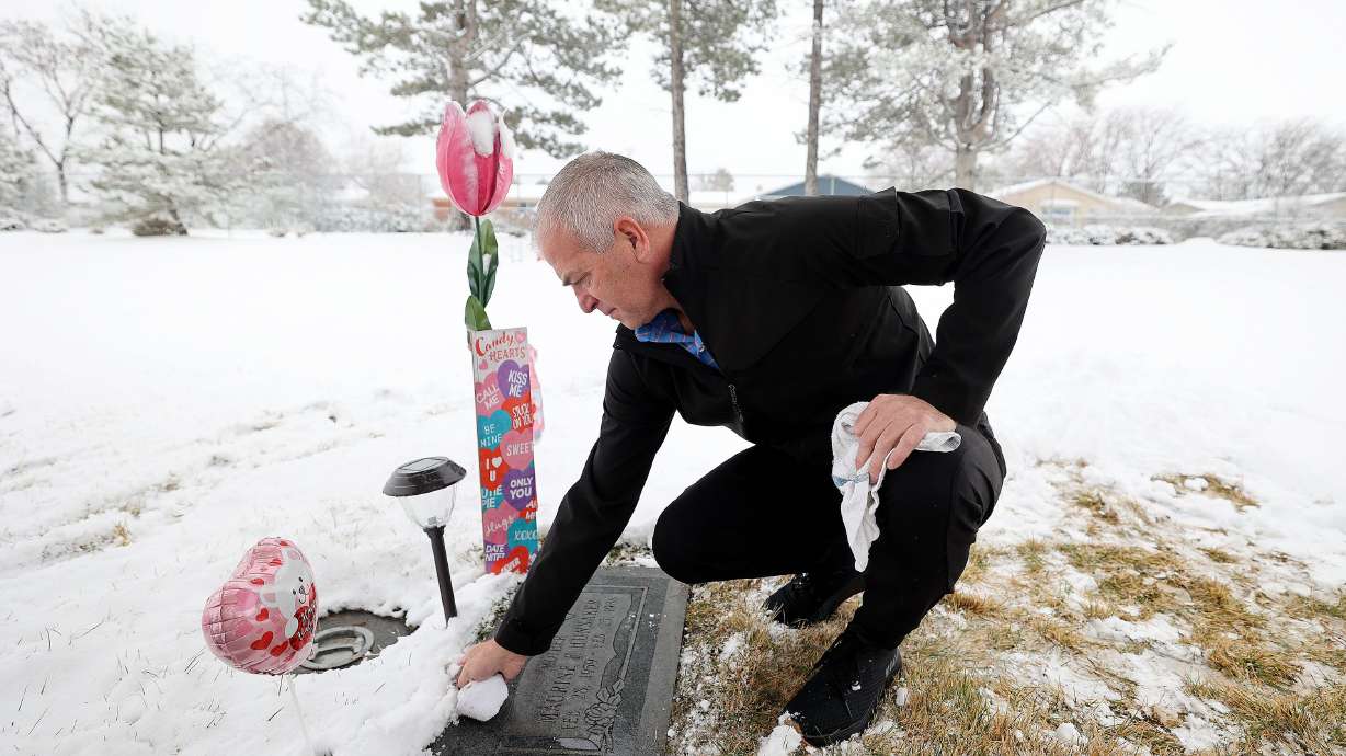 Matt Hunsaker cleans off the grave of his mother Maurine Hunsaker, who was murdered in 1986, at Valley View Memorial Park in West Valley City on Feb. 9. The court has ordered a competency hearing before the execution of her killer Ralph Menzies is to proceed.