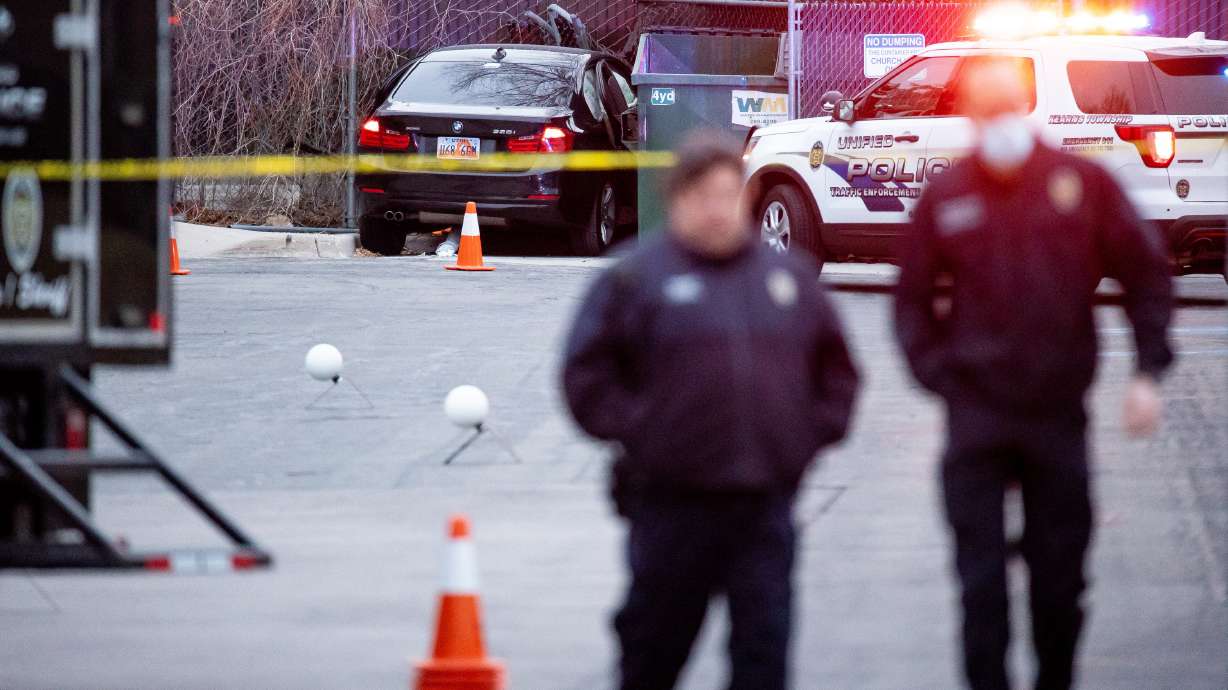 A black BMW involved in a fatal shooting is seen as Unified police officers investigate the scene in Kearns on March 9, 2021. One of the gunmen convicted for the crime was sentenced Thursday to at least 36 years, and up to life, in prison.