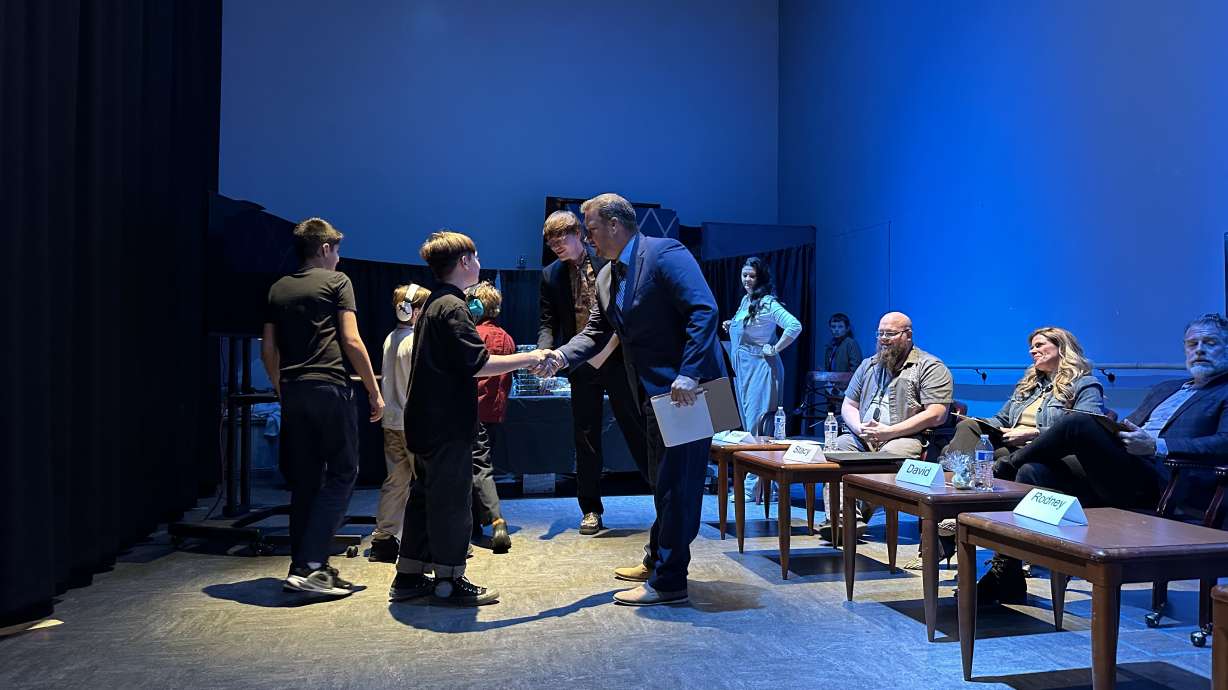 Franklin Discovery Academy fifth graders Jace Beebe, Stanley Richins and Oliver Bateman shake hands with "sharks" after making a deal on their comfy headphone design during a Utah "Shark Tank" entrepreneurial experience Wednesday.