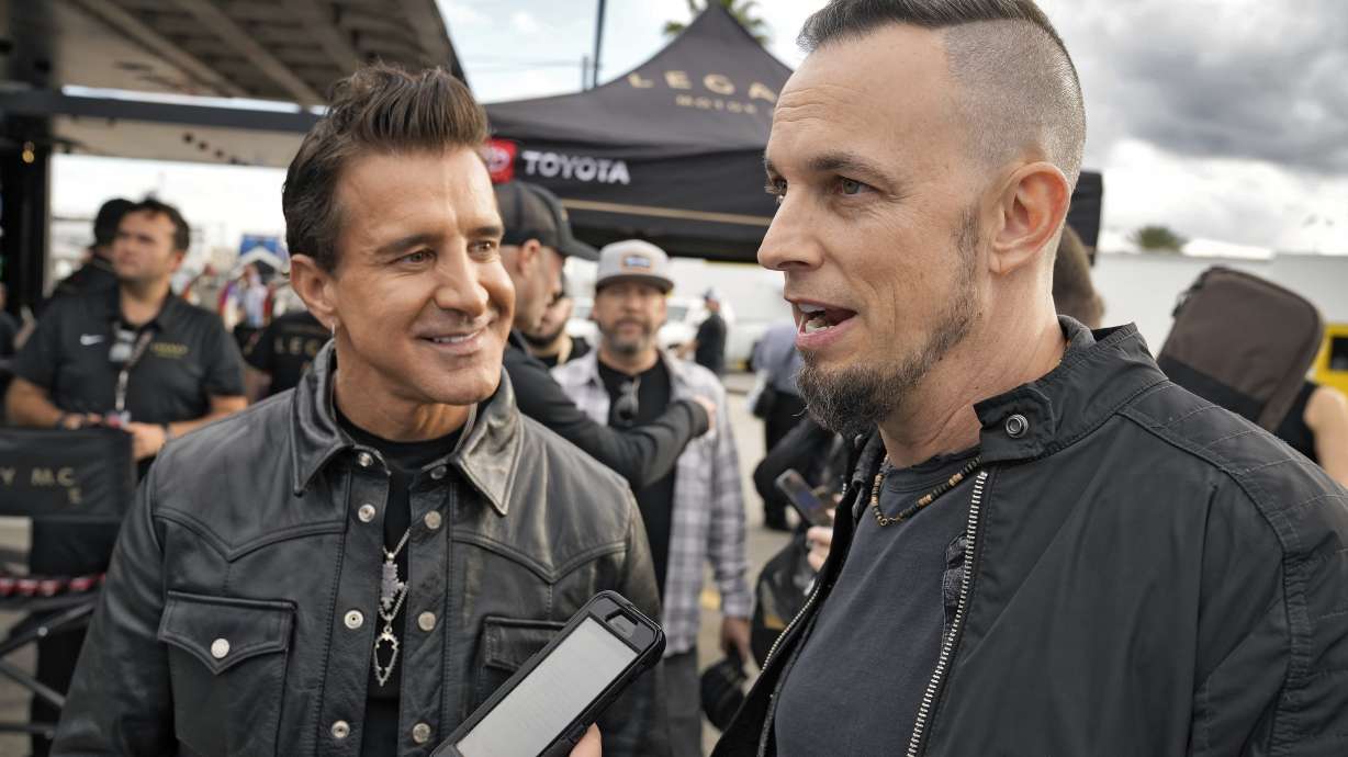 Scott Stapp, left, and Mark Tremonti, right, members of the rock band Creed, take part in an interview during an NASCAR Daytona 500 practice auto race Thursday, Feb. 15, 2024, at Daytona International Speedway in Daytona Beach, Fla.