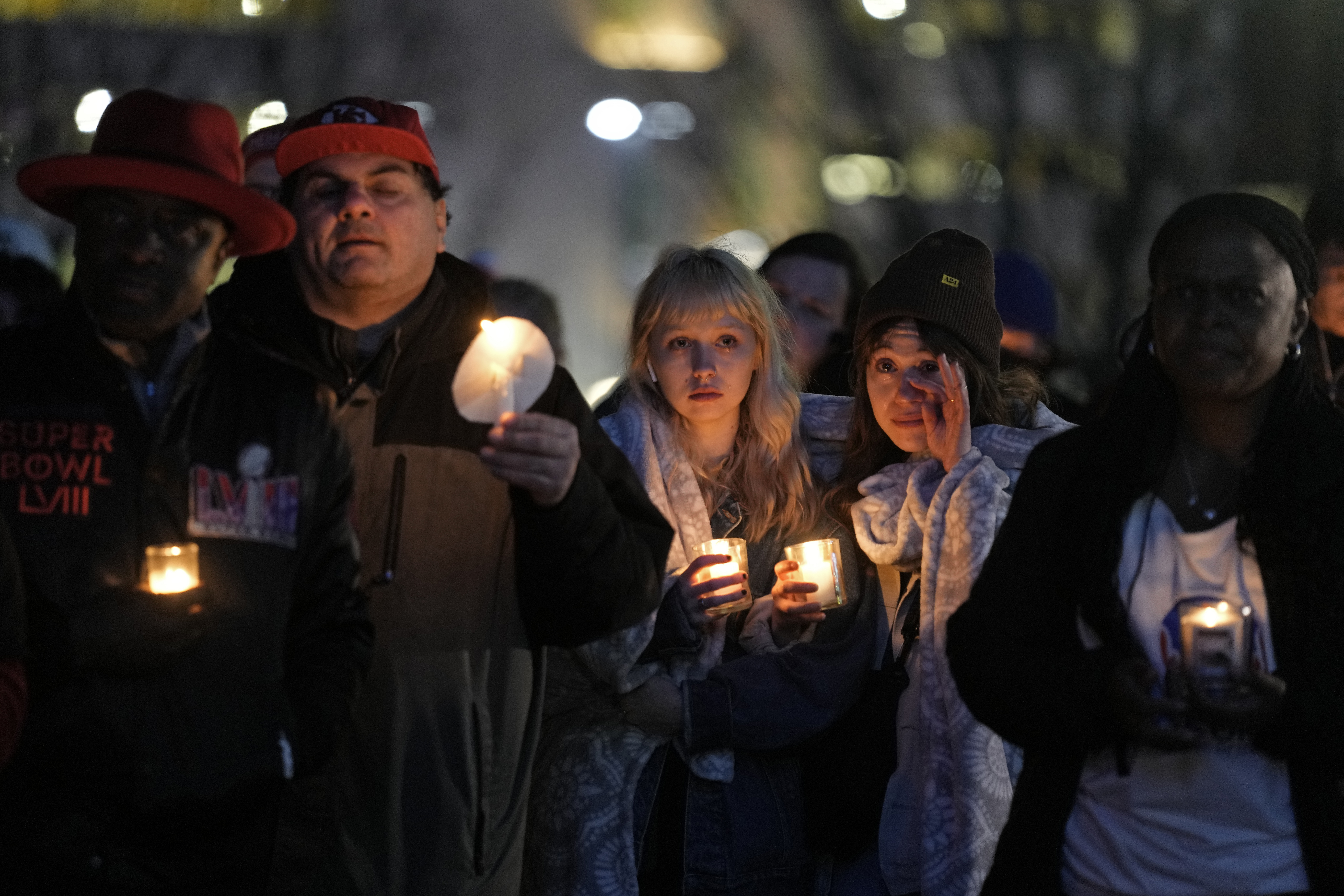 People attend a candlelight vigil for victims of a shooting at a Kansas City Chiefs Super Bowl victory rally Thursday in Kansas City, Mo. Two juveniles have been charged with crimes connected to the shooting at the rally, authorities said Friday.