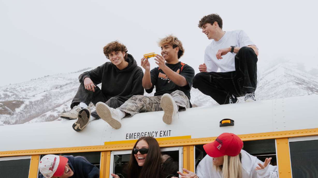 Collin McLaughlin and friends pose for a photo atop their increasingly popular vintage retail space housed in a school bus. They drive the bus around Utah, bringing with them a unique shopping experience.