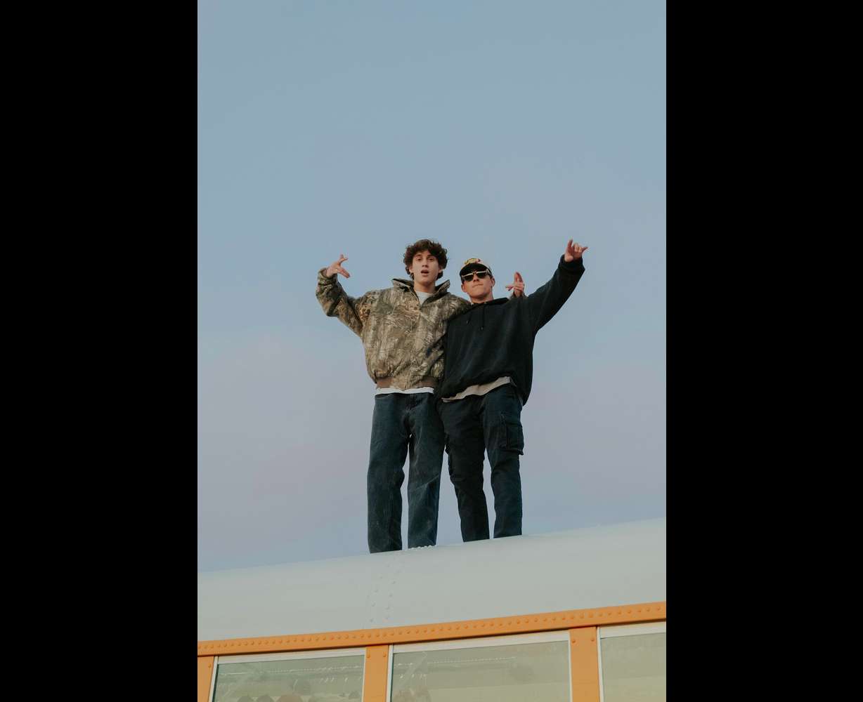 Collin McLaughlin and Kaysen Stevens posing on top of the bus.