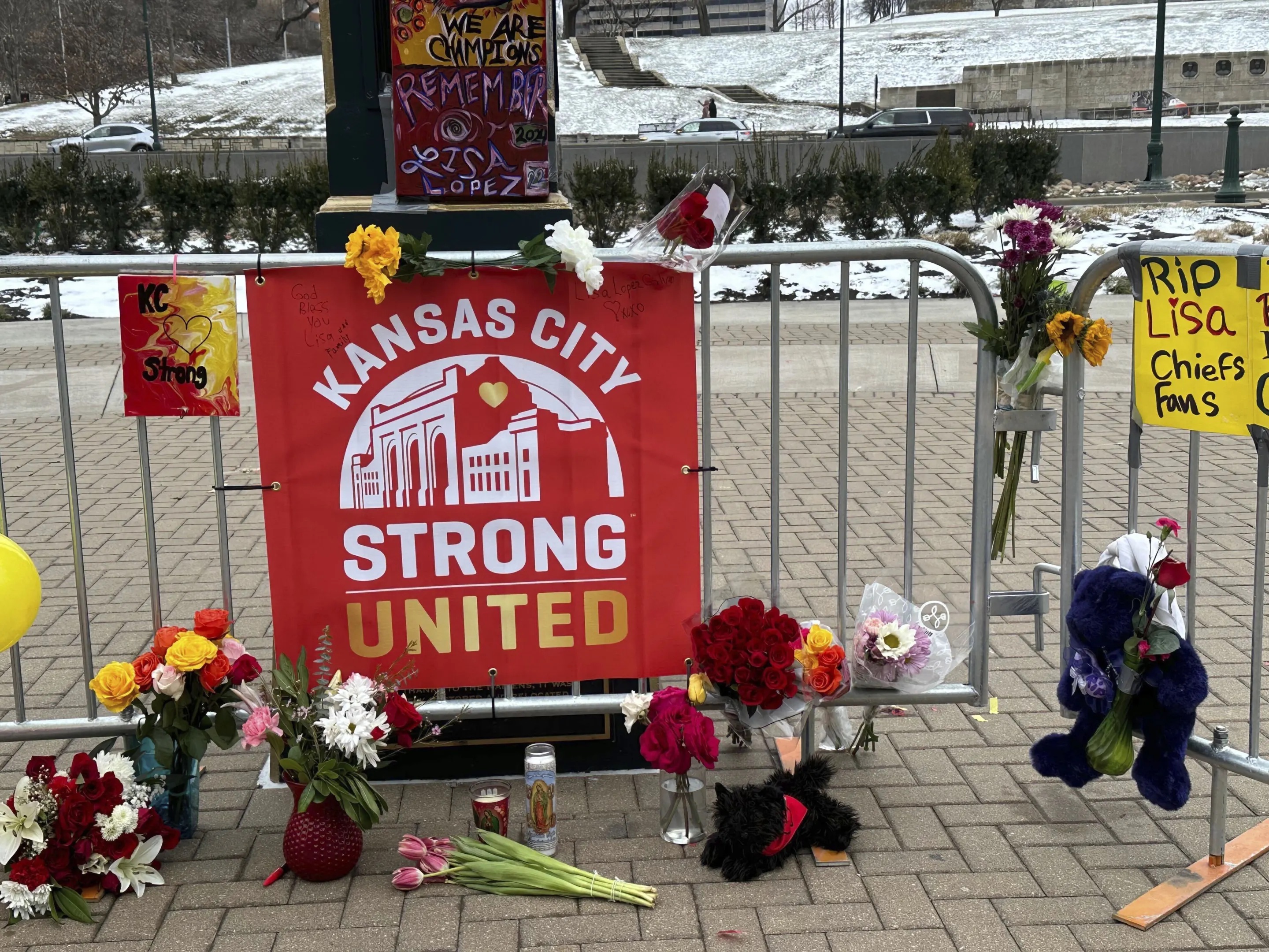 Flowers, signs and other items are gathered in front of Union Station, Kansas City, Mo. on Friday.