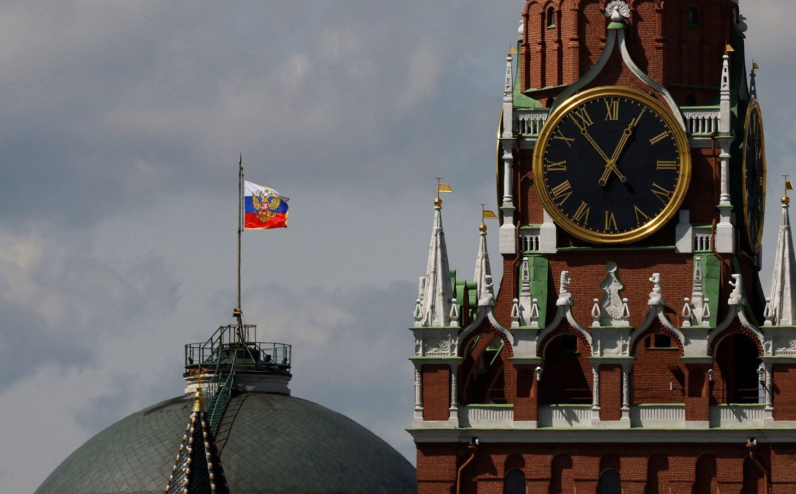 The Russian flag flies on the dome of the Kremlin Senate building behind Spasskaya Tower, while the roof shows what appears to be marks from a recent drone incident, in central Moscow, Russia, May 4, 2023.