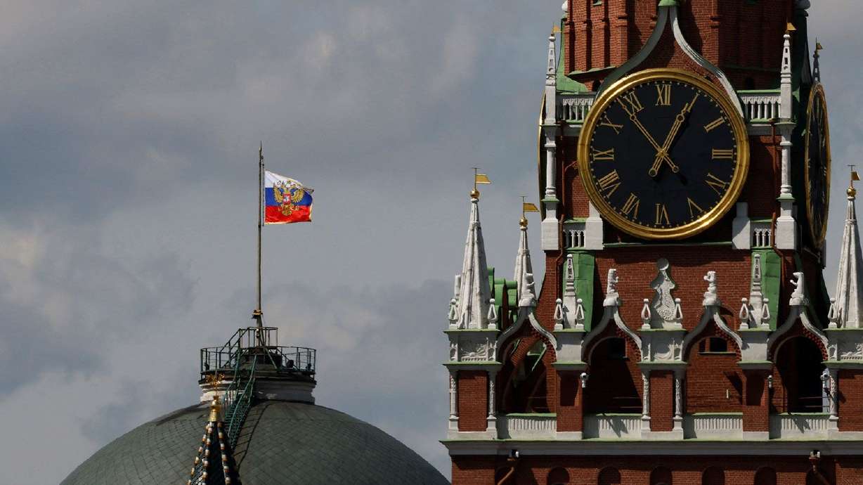 The Russian flag flies on the dome of the Kremlin Senate building behind Spasskaya Tower, while the roof shows what appears to be marks from a recent drone incident, in central Moscow, Russia, May 4, 2023.