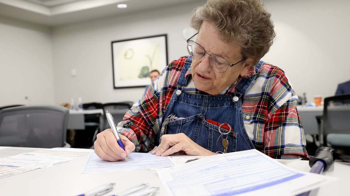 Karen Cravens fills out a passport application at the State Department’s Salt Lake City Passport Fair at the Bennett Federal Building in Salt Lake City on Friday.