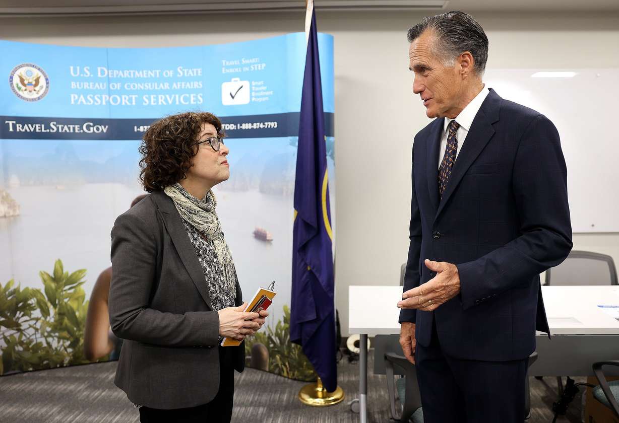U.S. Assistant Secretary of State for Consular Affairs Rena Bitter and Sen. Mitt Romney, R-Utah, talk while visiting the State Department’s Salt Lake City Passport Fair at the Bennett Federal Building in Salt Lake City on Friday.
