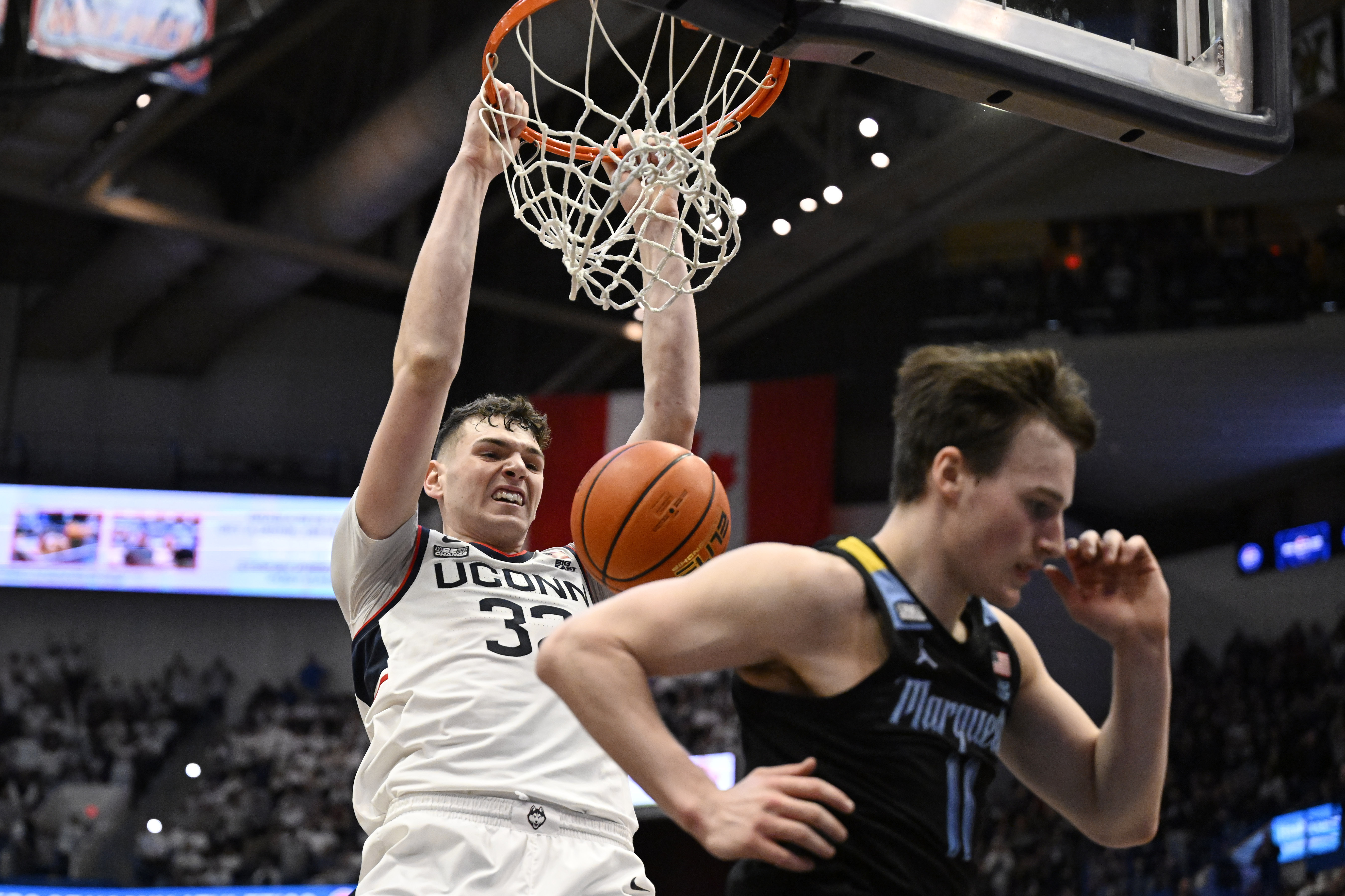 UConn center Donovan Clingan dunks behind Marquette guard Tyler Kolek (11) in the first half of an NCAA college basketball game, Saturday, Feb. 17, 2024, in Hartford, Conn. 