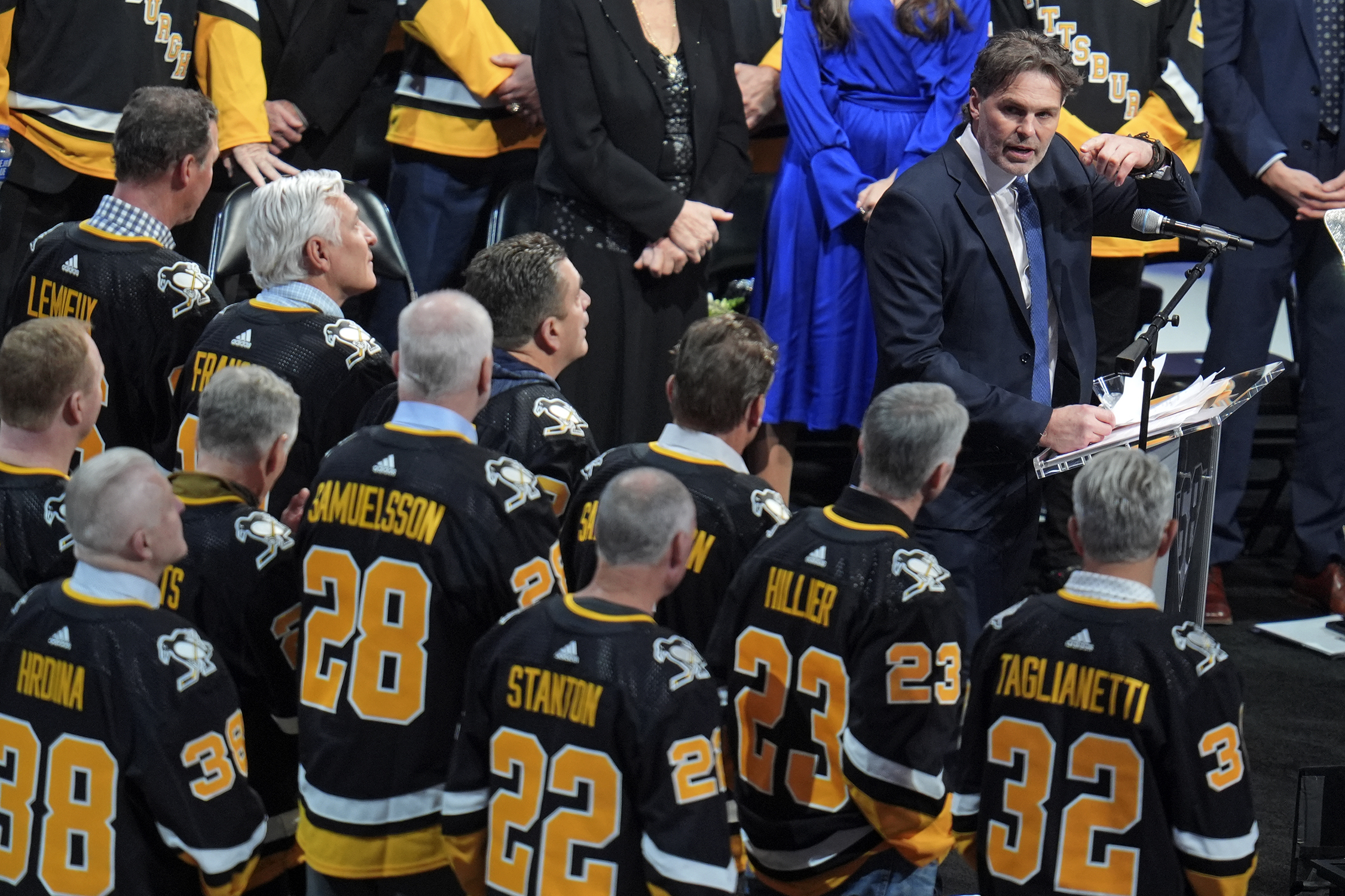 Former Pittsburgh Penguins player Jaromir Jagr, at podium to right, is joined by former teammates as he speaks during a ceremony retiring his uniform number before an NHL hockey game between the Los Angeles Kings and Pittsburgh Penguins in Pittsburgh, Sunday, Feb. 18, 2024. 