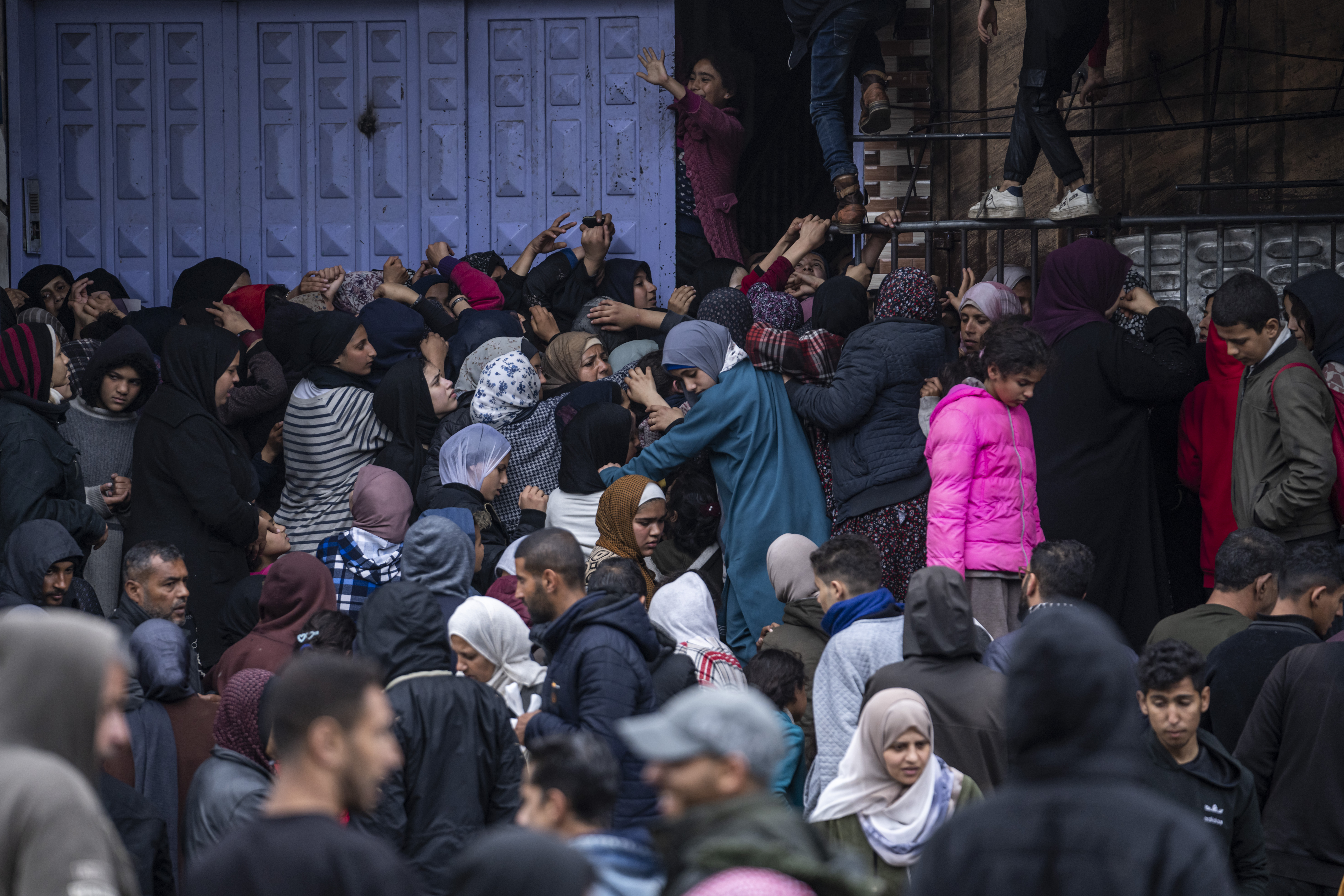 Palestinian crowds struggle to buy bread from a bakery in Rafah, Gaza Strip, Sunday. International aid agencies say Gaza is suffering from shortages of food, medicine and other basic supplies as a result of the war between Israel and Hamas.