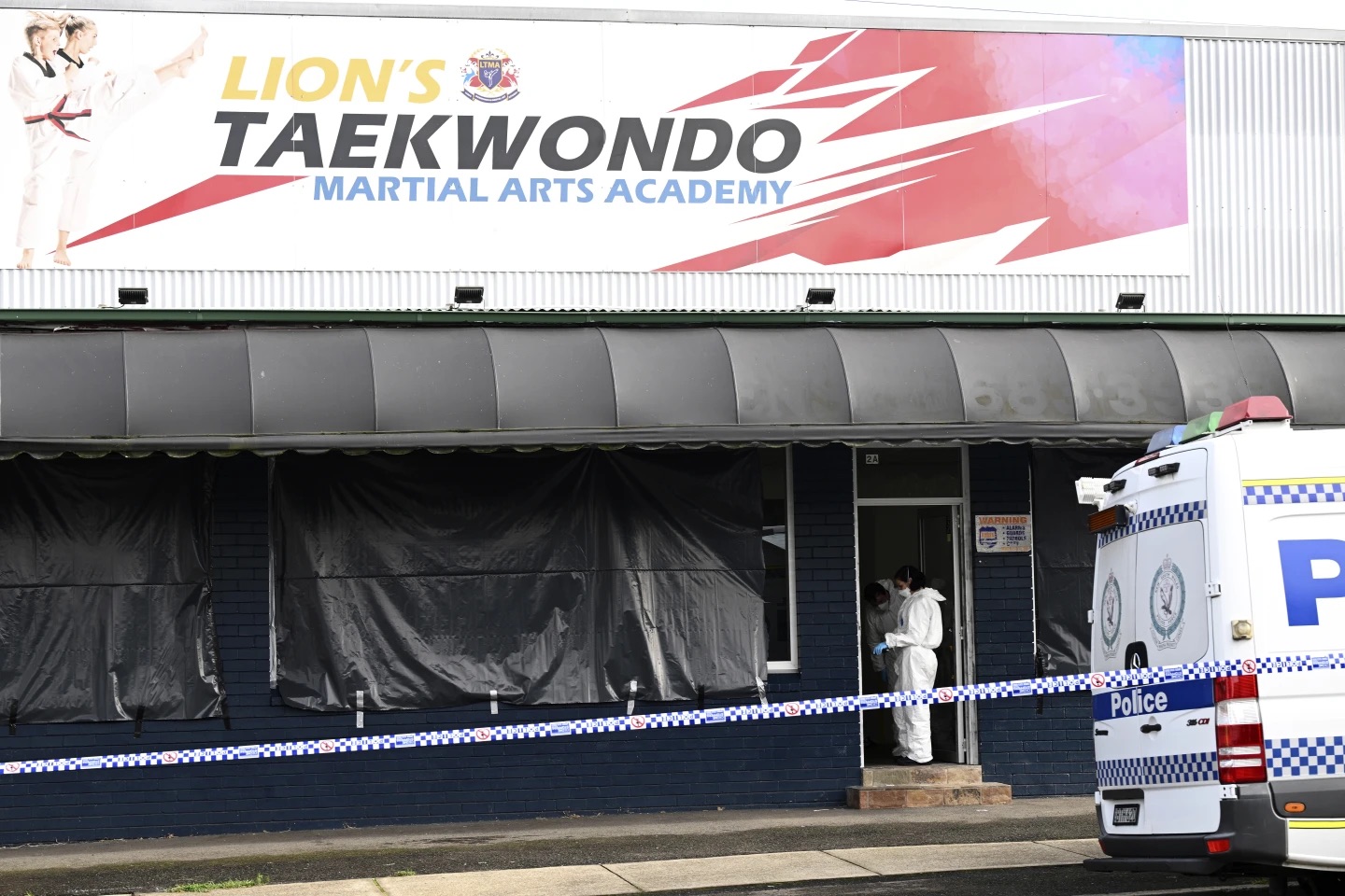 Police investigate a crime scene in Sydney, Australia, on Wednesday. Police say a taekwondo instructor killed a 7-year-old student and the boy's parents. 