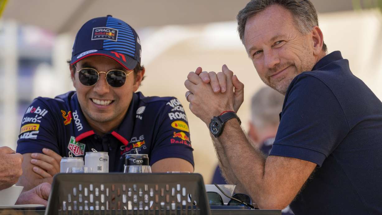 Red Bull team principal Christian Horner, right, chats with Red Bull driver Sergio Perez of Mexico at the pits during Formula One pre season test at the Bahrain International Circuit in Sakhir, Bahrain, Wednesday, Feb. 21, 2024.