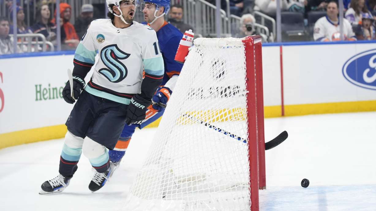 Seattle Kraken's Matty Beniers (10), left, reacts after scoring during the first period of an NHL hockey game against the New York Islanders, Tuesday, Feb. 13, 2024, in Elmont, N.Y.