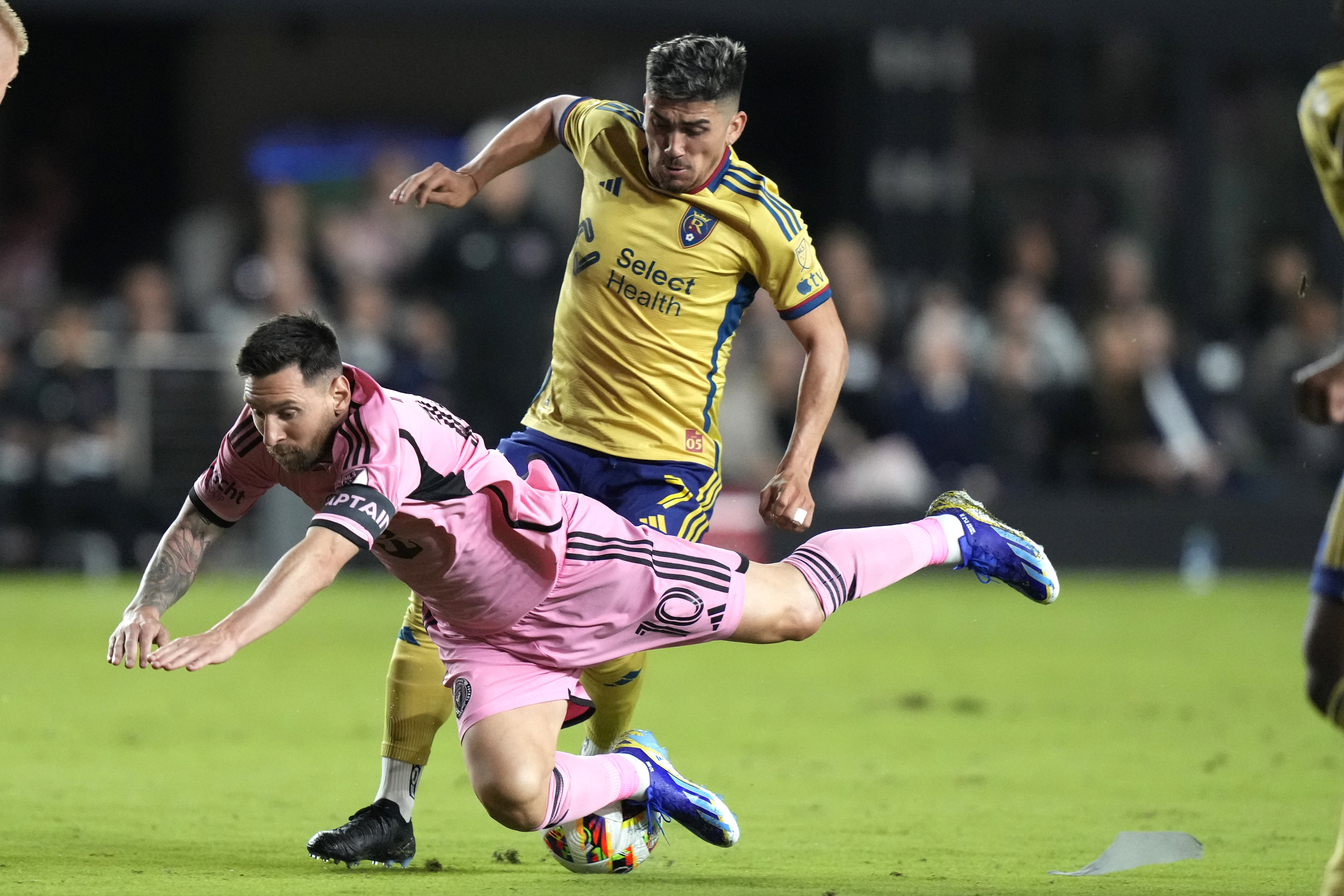 Inter Miami forward Lionel Messi, front, falls to the field after coming into contact with Real Salt Lake midfielder Pablo Ruiz during the first half of an MLS soccer match Wednesday, Feb. 21, 2024, in Fort Lauderdale, Fla. Ruiz was given a yellow card on the play. 