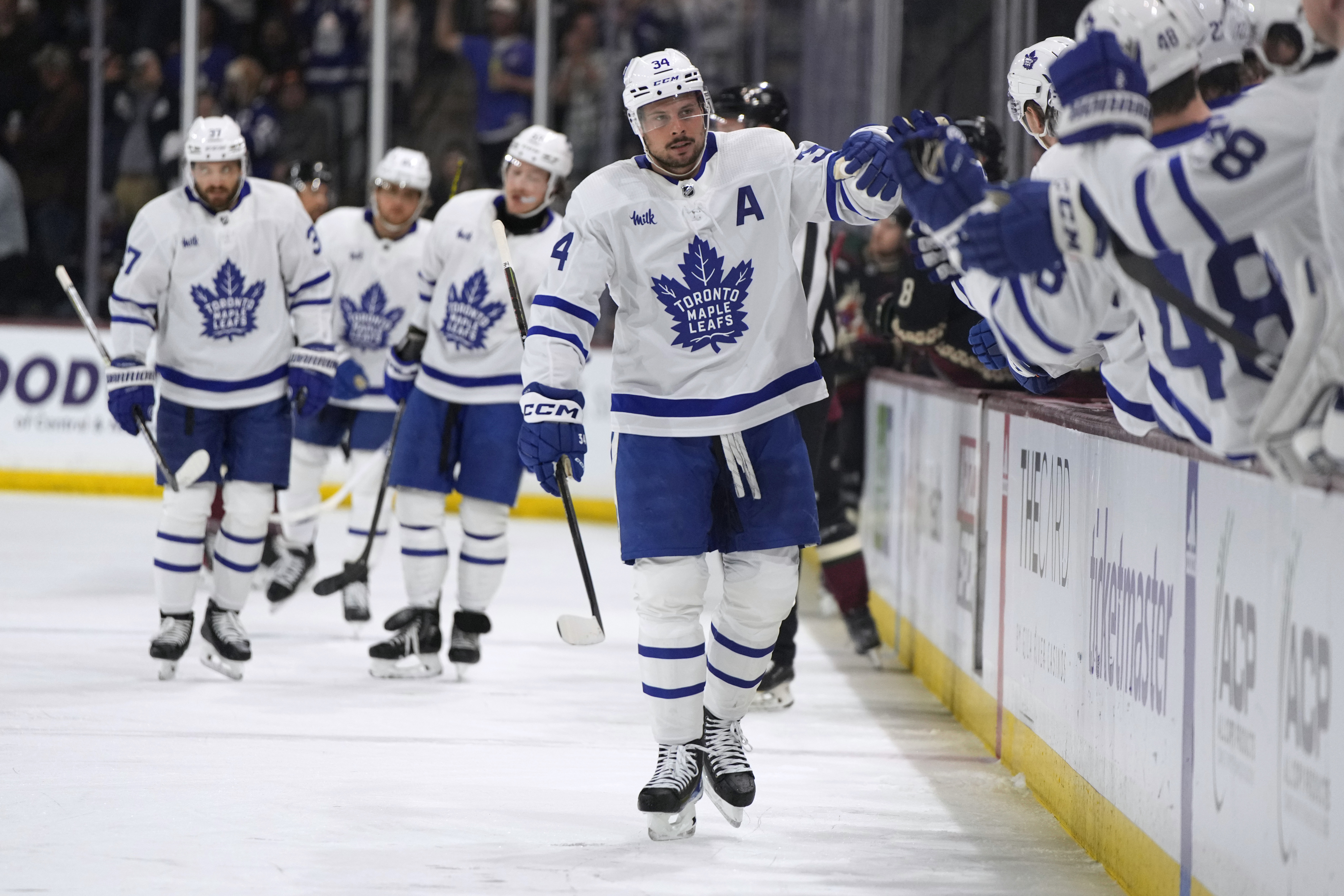 Toronto Maple Leafs center Auston Matthews (34) is congratulated after scoring his 50th goal of the season, against the Arizona Coyotes during the first period of an NHL hockey game Wednesday, Feb. 21, 2024, in Tempe, Ariz. 