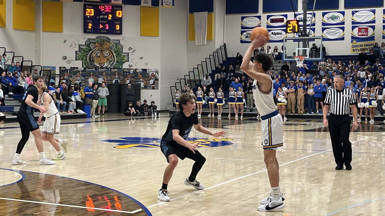 Orem's Jax Allen holds the ball out front against West Jordan's Steven Cox.