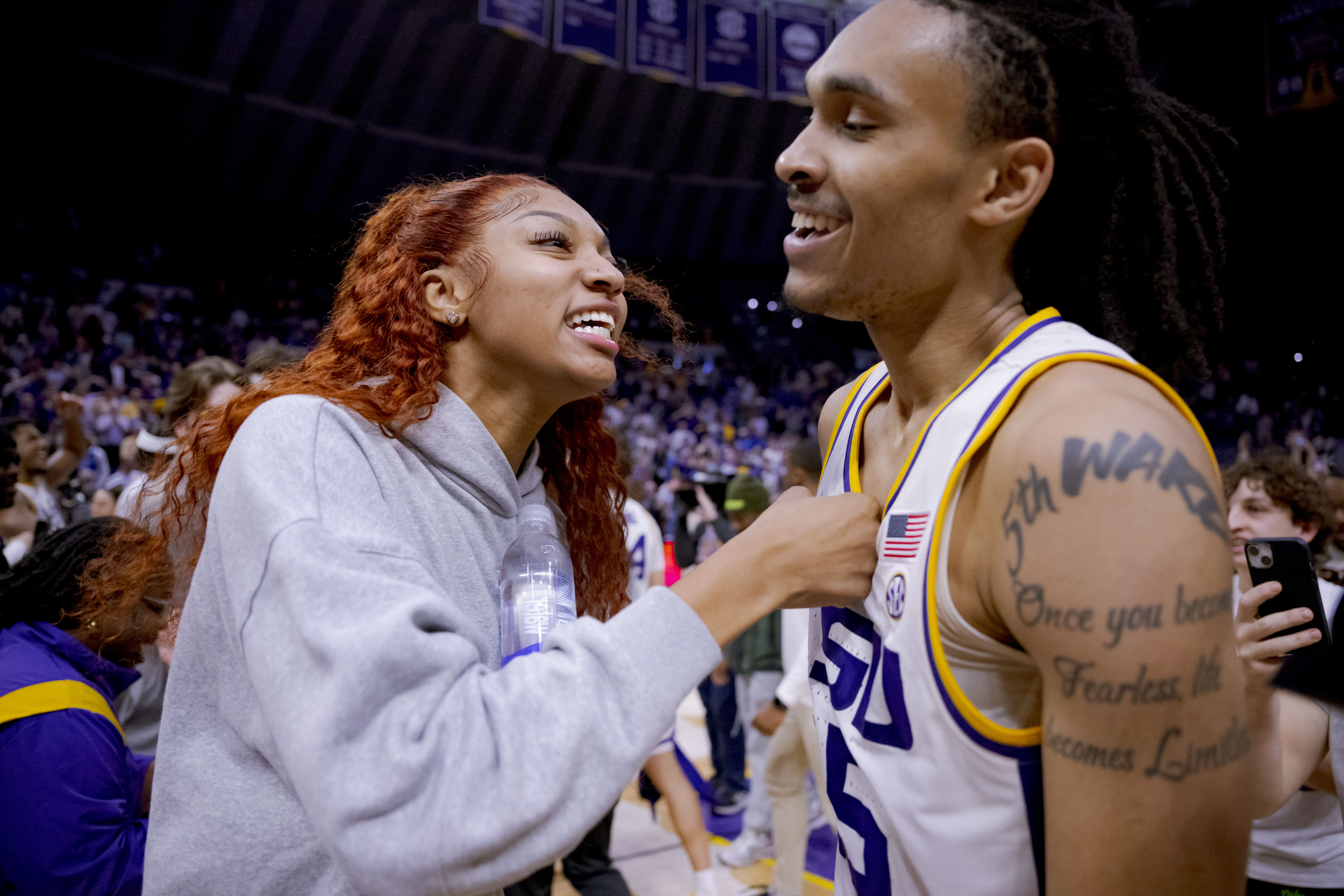 LSU students, including LSU women's basketball forward Angel Reese, left, rush the court after LSU forward Tyrell Ward (15) hit the game-winning shot against Kentucky in an NCAA college basketball game in Baton Rouge, La., Wednesday, Feb. 21, 2024.