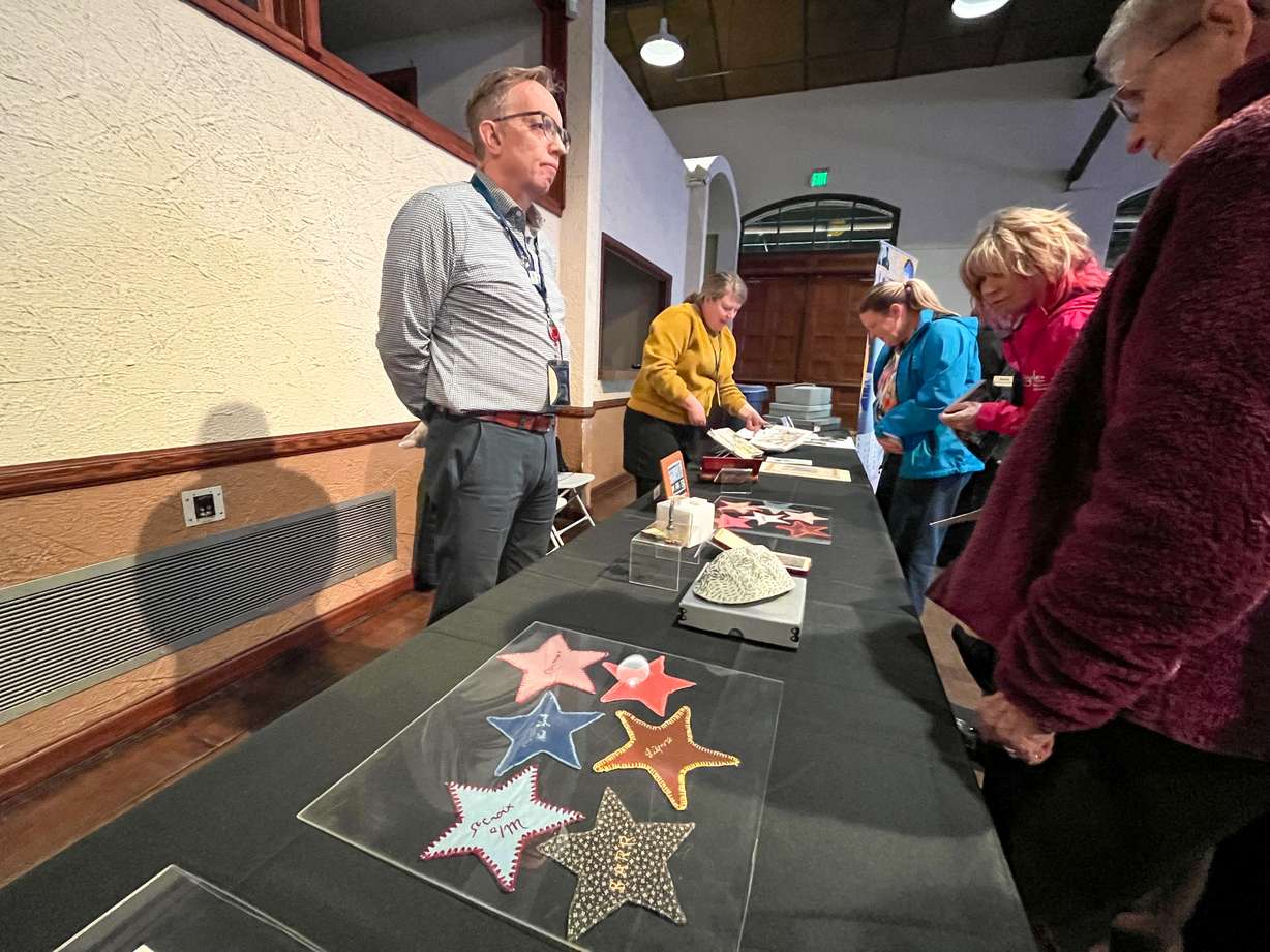 Alan Barnett, archiviste du gouvernement local pour la Division des archives et du service des archives de l'Utah, présente certains des cadeaux que le peuple français a envoyés à l'Utah en 1949 via le train « Merci » lors d'un événement honorant le 75e anniversaire de son arrivée à la gare Union d'Ogden. Jeudi soir.