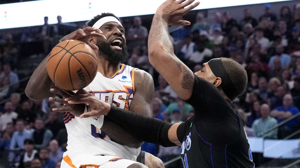 Phoenix Suns forward Royce O'Neale, left, loses control of the ball on a drive to the basket as Dallas Mavericks' Daniel Gafford, right, defends in the first half of an NBA basketball game in Dallas, Thursday, Feb. 22, 2024.