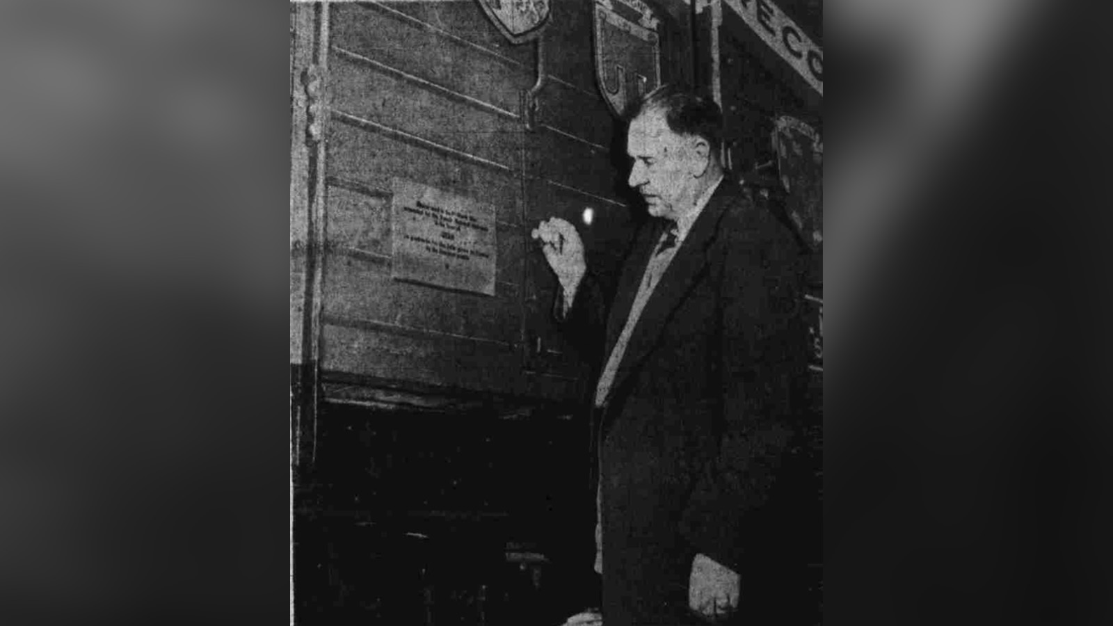 H.M. McNeil, chairman of a committee to welcome the "Merci" boxcar, reads an inscription on the boxcar after it arrived in Salt Lake City on Feb. 18, 1949.
